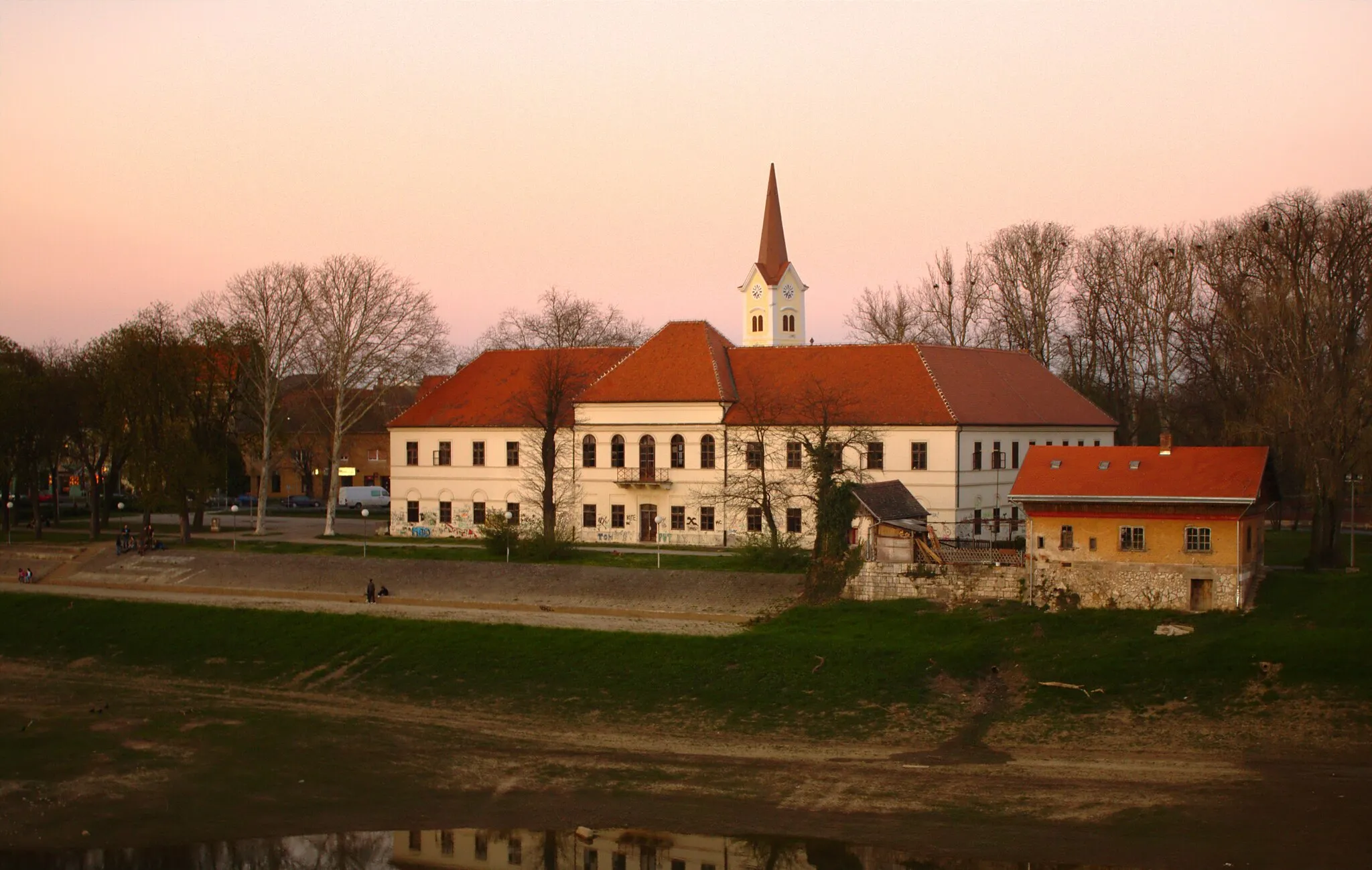 Photo showing: A small yard in Sisak, Croatia during sunset. The picture was taken from a nearby bridge across the Kupa River