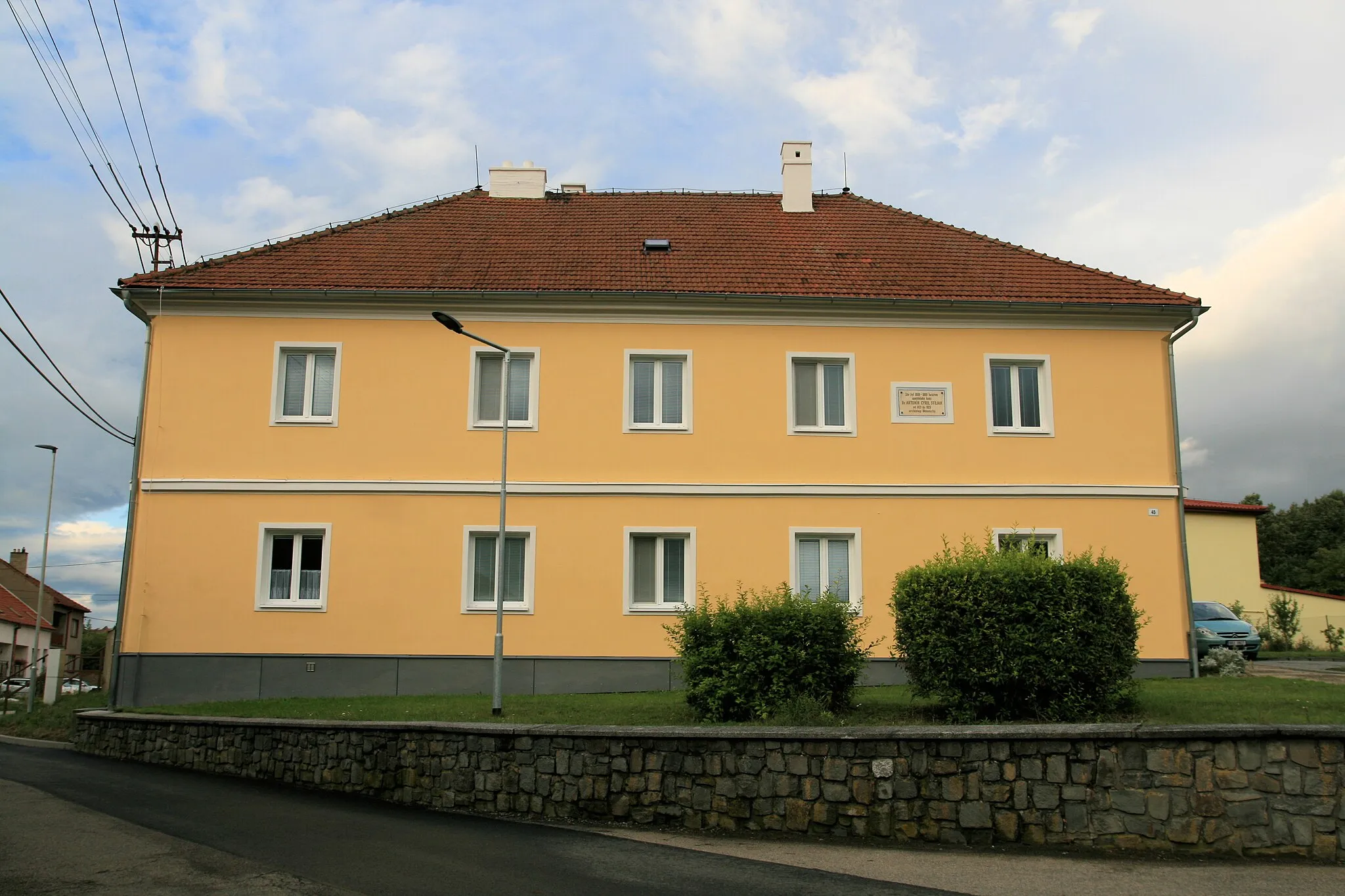 Photo showing: Dražovice, okres Vyškov. Barokní fara z roku 1792, před ní kříž s nápisem "Pochválen buď Pán Ježíš Kristus", na fasádě pamětní deska s nápisem "Zde byl 1888 - 1908 farářem apoštolský kněz Dr. Antonín Cyril Stojan, od 1921 do 1923 arcibiskup Olomoucký."