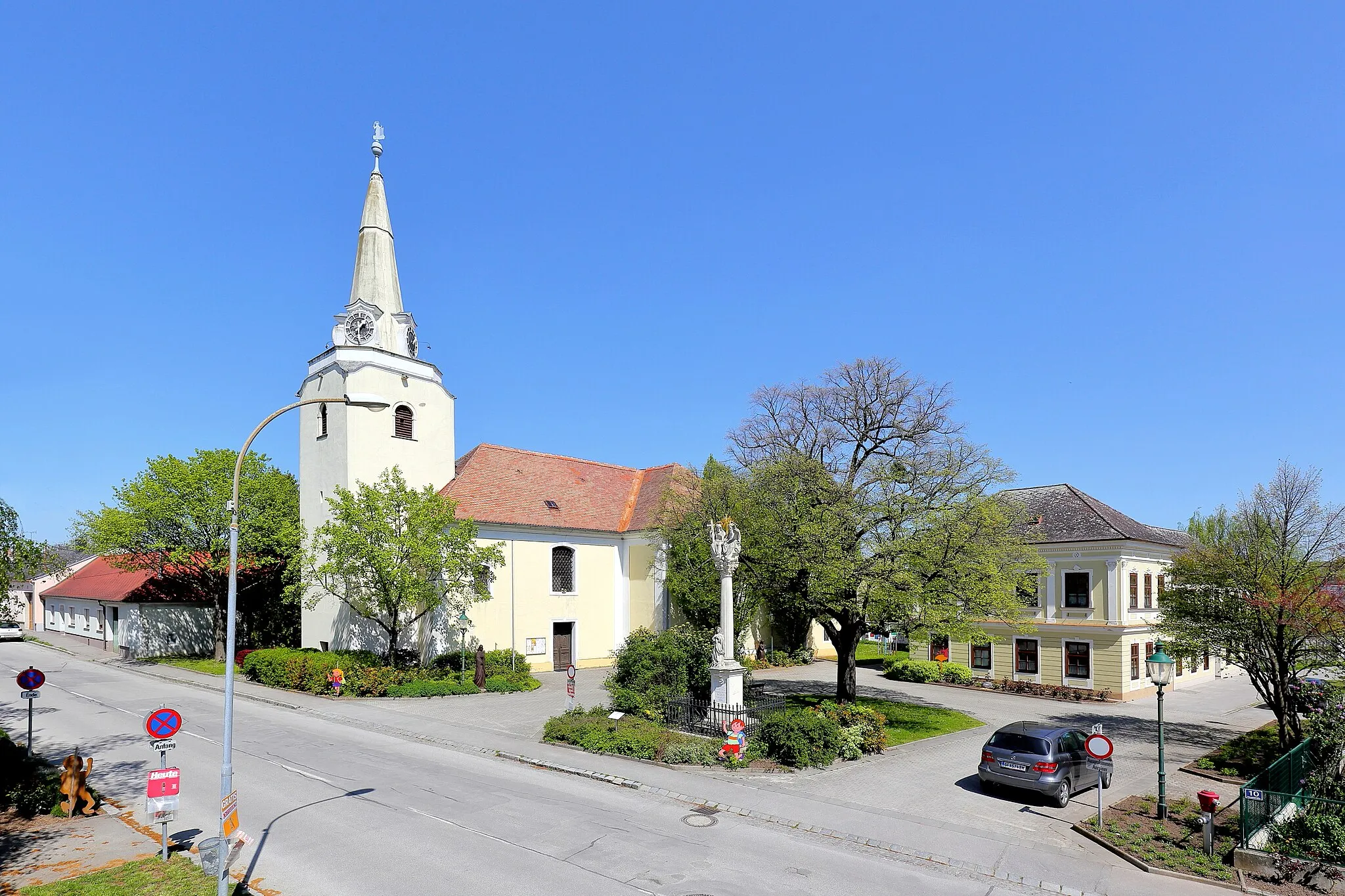 Photo showing: Ortszentrum der niederösterreichischen Marktgemeinde Drösing mit der Pfarrkirche hl. Laurentius, der Dreifaltigkeitssäule und der Volksschule (rechts).