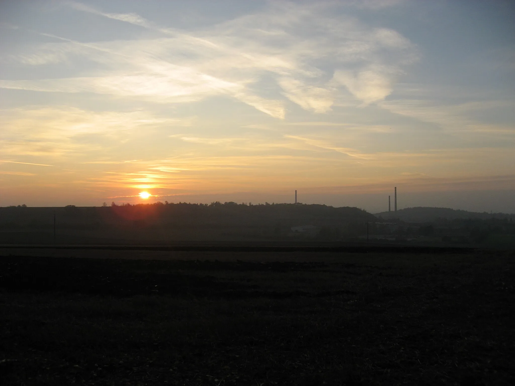 Photo showing: Brno, Slunce zapadající nad Stránskou skálou, pohled směrem od Líšně, z pole nad Zetorem, pod zahrádkářskou osadou (pravděpodobně z remízku).