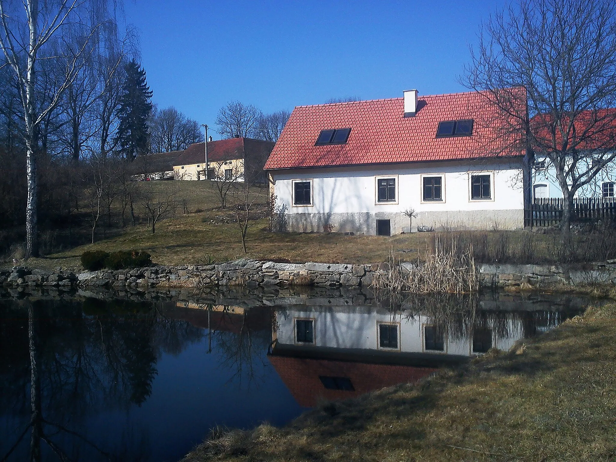 Photo showing: Pond and house No 15 in the village of Pořešinec, part of the town of Kaplice, South Bohemian Region, Czech Republic.