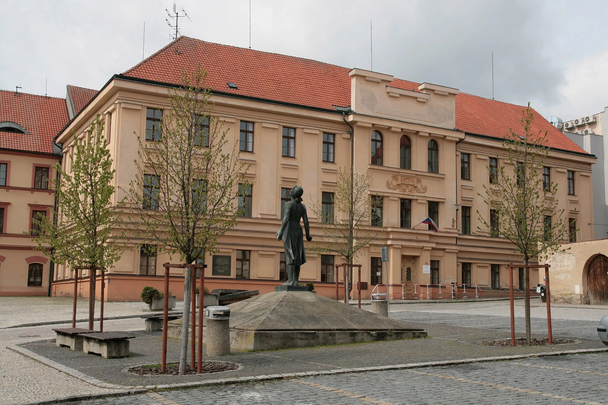 Photo showing: Město Domažlice. Pomník obětem nacismu na Chodském náměstí s bronzovou sochou Píseň vítězství od Otakara Švece. V pozadí budova Střední zdravotnické školy, bývalého gymnázia, v domě čp. 97.