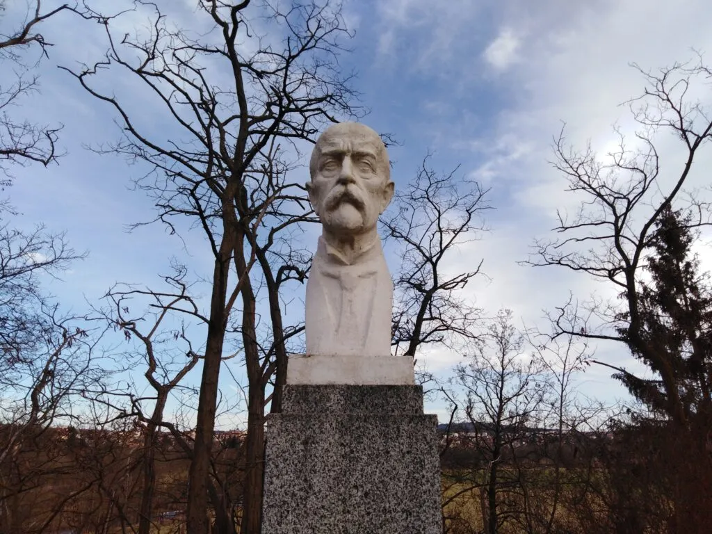 Photo showing: A publicly accessible granite monument dedicated to the memory of the victims of World War I and World War II is located on Plzeňská cesta (Plzeň 2 - Slovany, Hradiště; GPS coordinates 49.712327, 13.400411). Jaroslav Šindelář (* 11 June 1950, Plzeň) made a new bust of T. G. Masaryk for the monument in 1990, which is located at the top of the central prism. On the sides of the monument there are stone tablets with a list of names of people who died for freedom in 1914-1918 and 1938-1945.