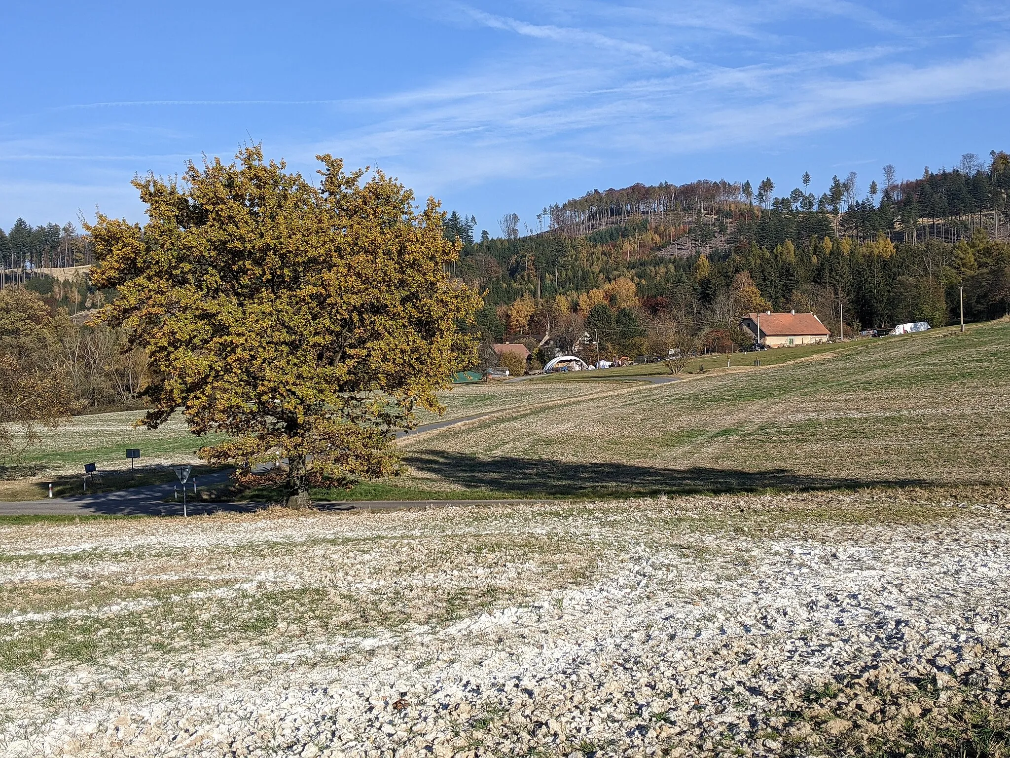 Photo showing: Hutě - osada u Jinošic, v pozadí hřbet Žebráka