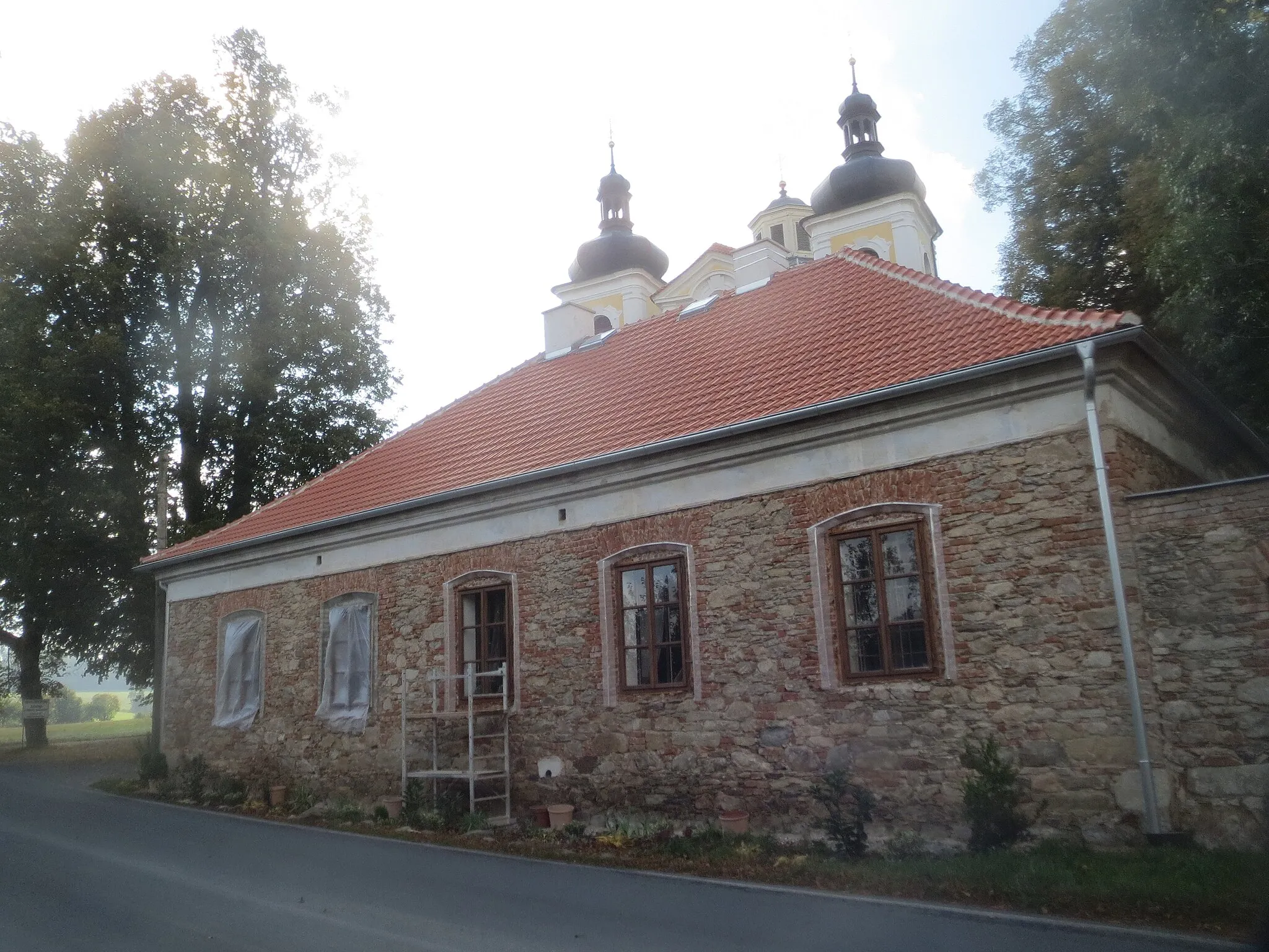 Photo showing: Ehemaliges Pfarrhaus in Planice Nicov (2. Hälfte 19. Jhdt.); Wallfahrtskirche Maria Geburt im Hintergrund.