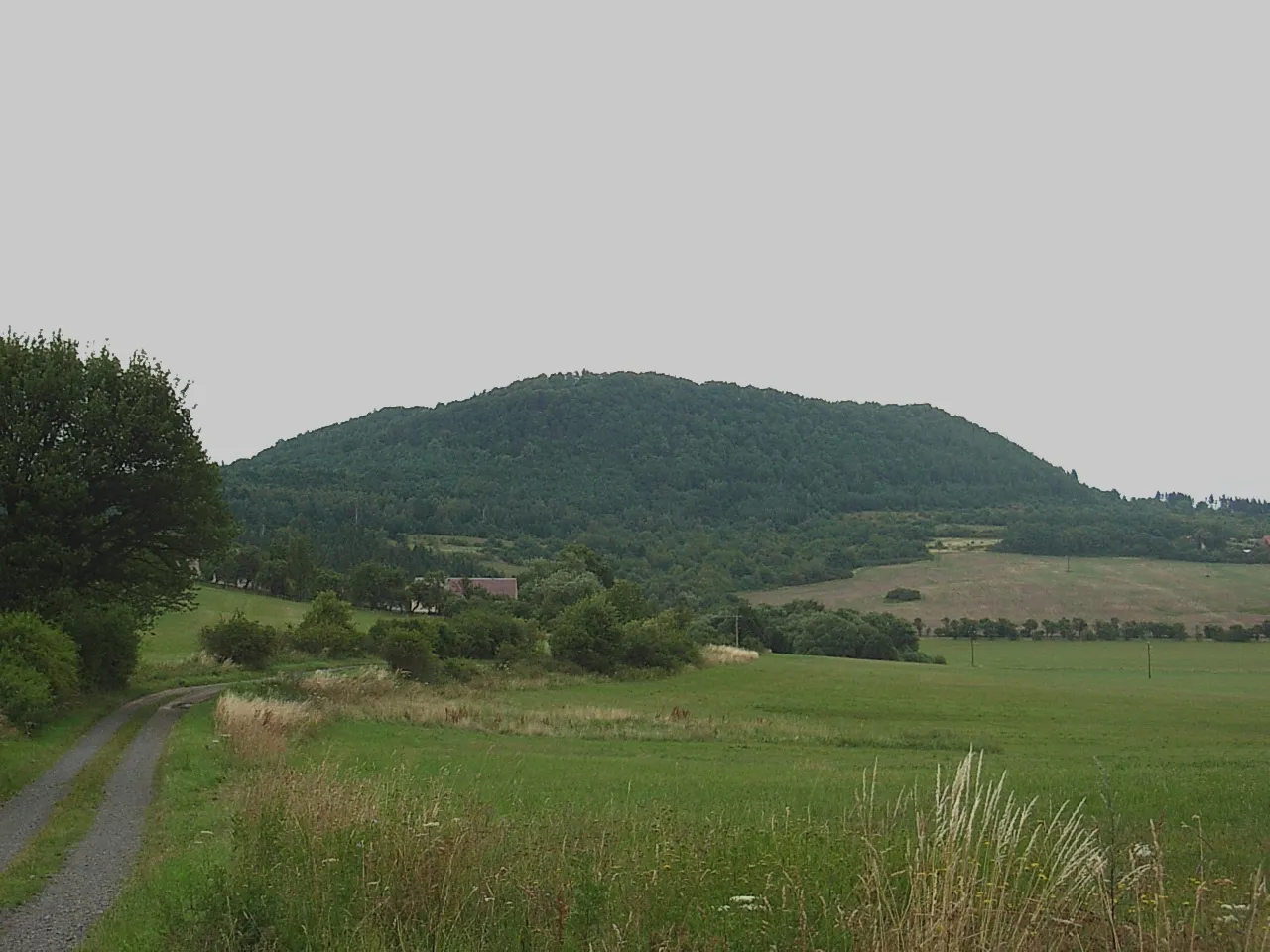 Photo showing: Pohled na vrch Vladař od jihozápadu, přes Kolešov. Zcela při pravém okraji pod obzorem Vladořice.