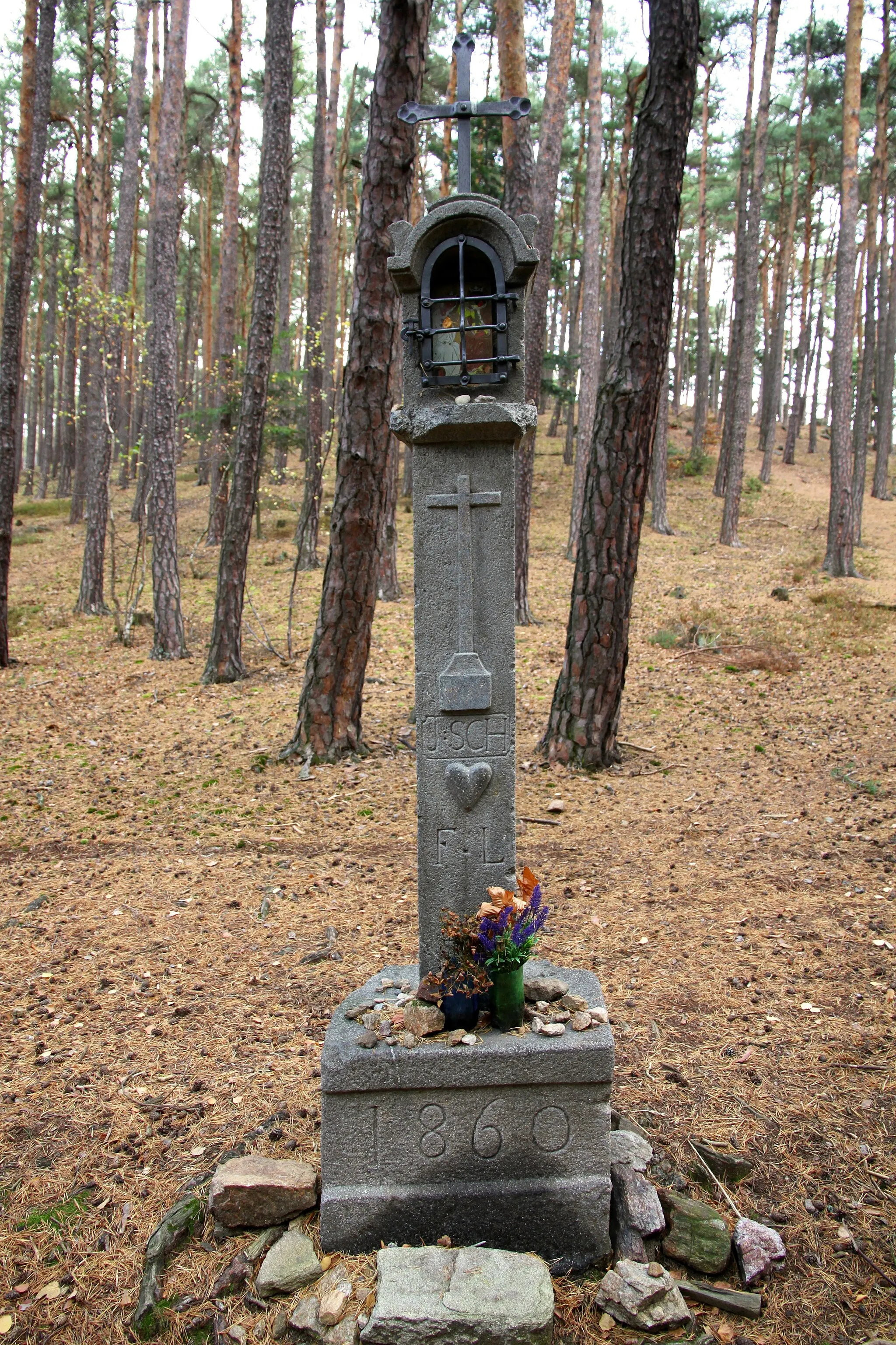 Photo showing: Stone column shrine dated 1860 at the crossroads of forest paths on the blue tourist trail from Cvrckov to Prachatice, South Bohemian Region, Czechia.
