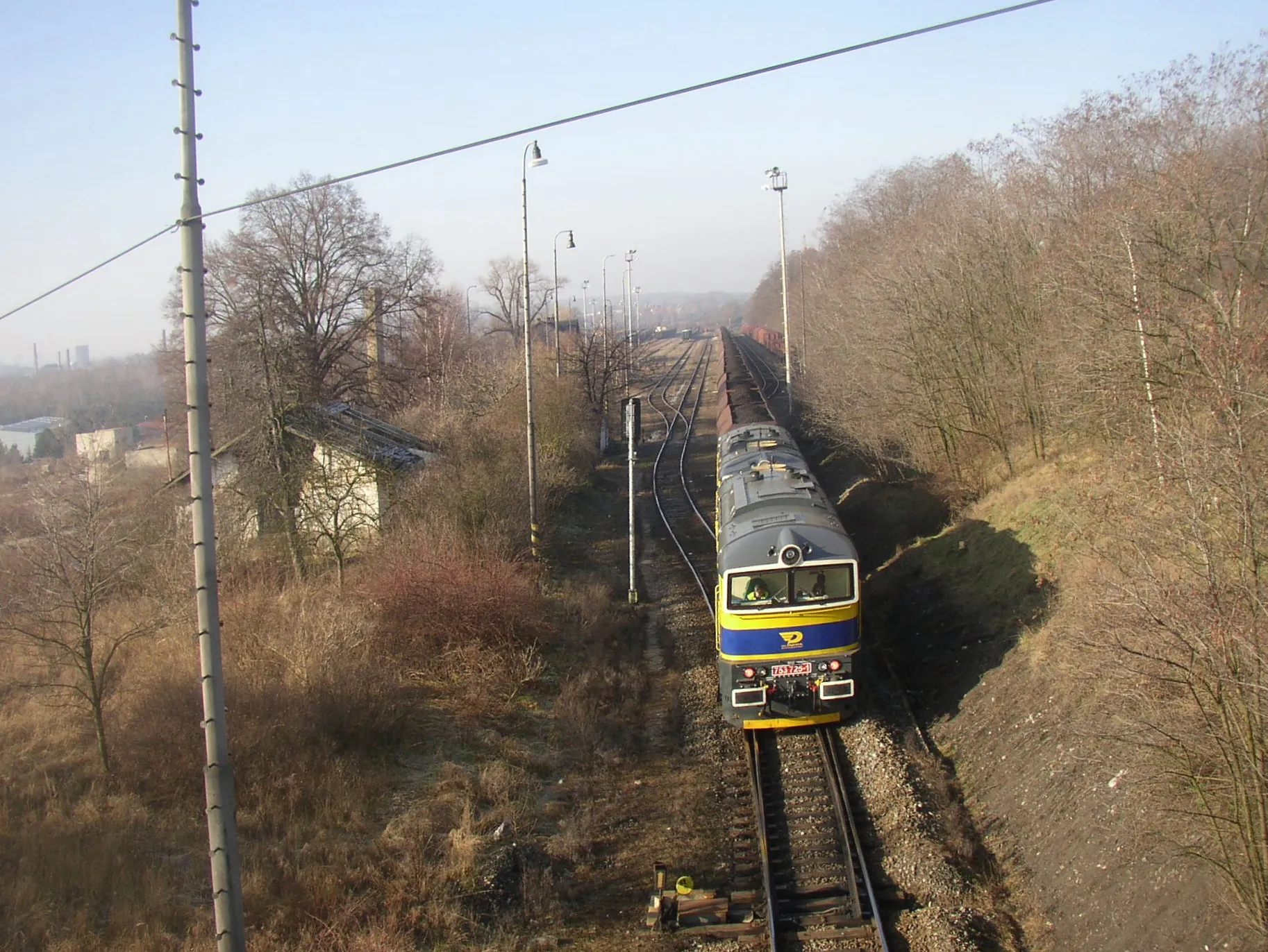 Photo showing: Scheduled freight train with coal from Ledvice for Kladno power plant just has entered Kladno-Dubí railway station on line 093 Kralupy nad Vltavou - Kladno. Coupled Class 753 locomotives in livery of OKD, Doprava company are pushing the tran.