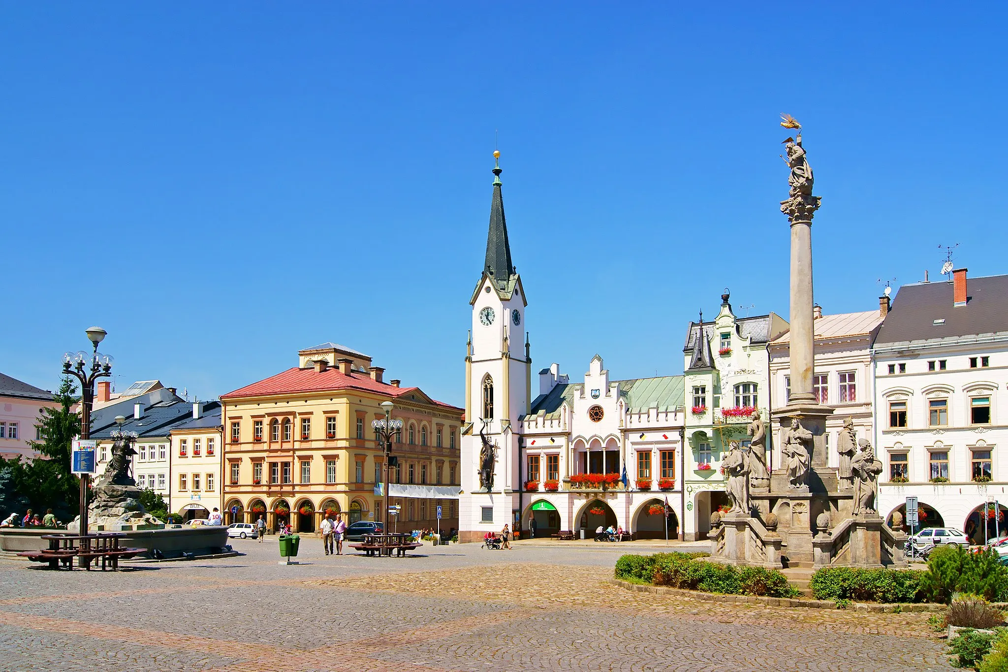 Photo showing: Krakonošovo náměstí v Trutnově. Vlevo Krakonošova kašna, uprostřed novogotická stará radnice, vpravo barokní sloup Nejsvětější Trojice.
