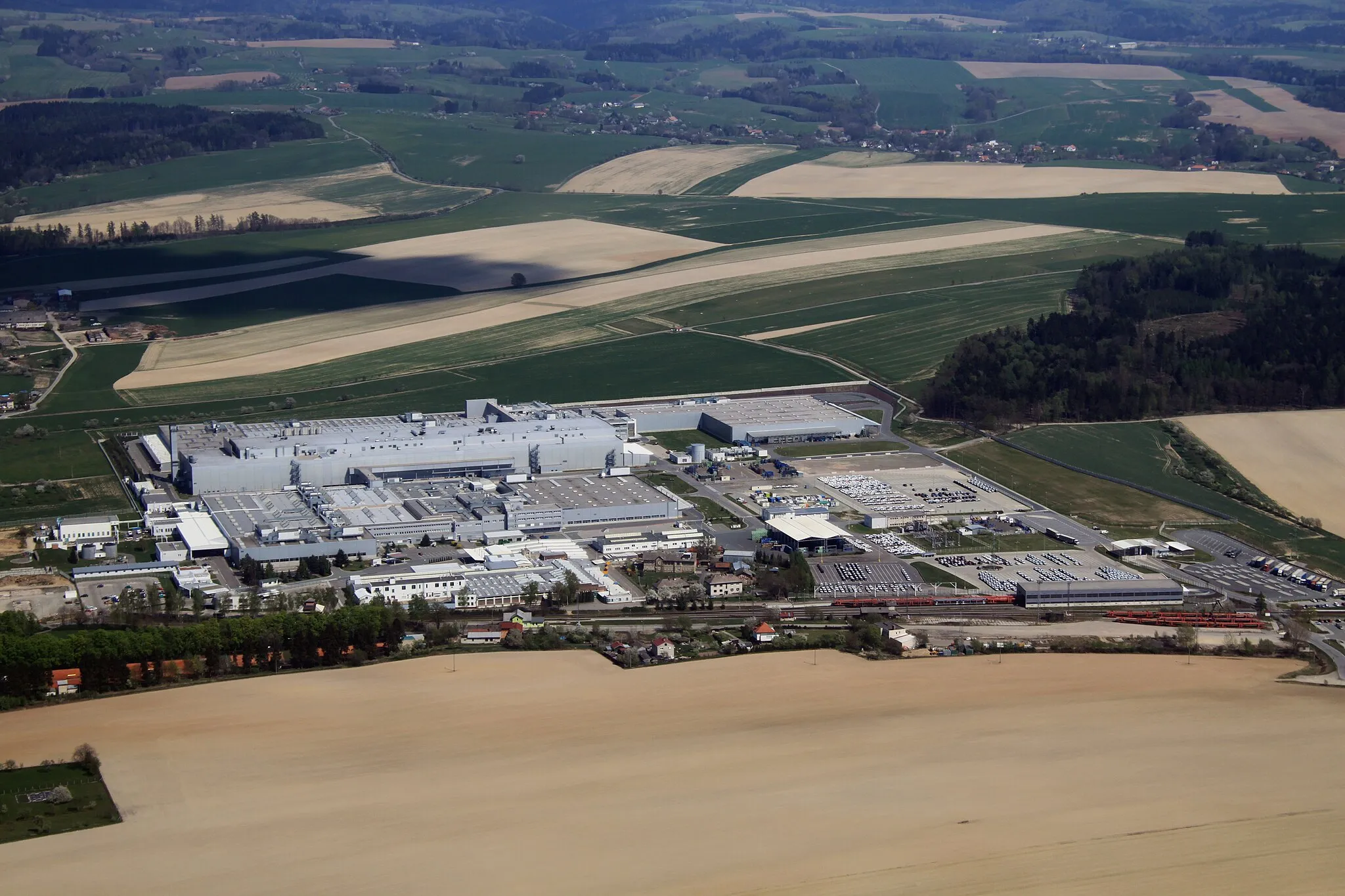 Photo showing: Škoda car producing factory near village Kvasiny and town Rychnov nad Kněžnou from air, vilage Lukavice on background, eastern Bohemia, Czech Republic