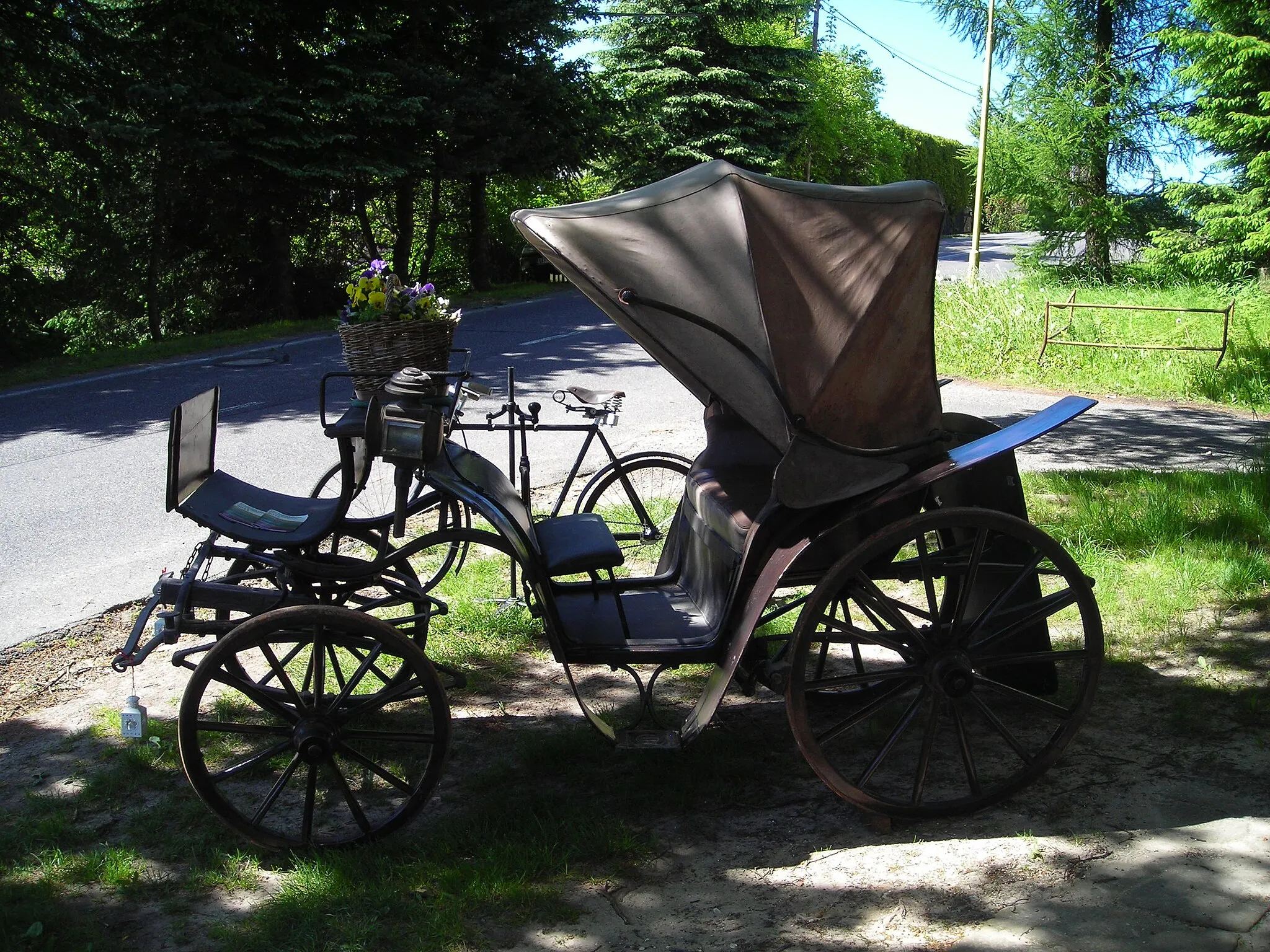 Photo showing: Starý kočár a kolo před kostelem v Petrovicích, okres Liberec.