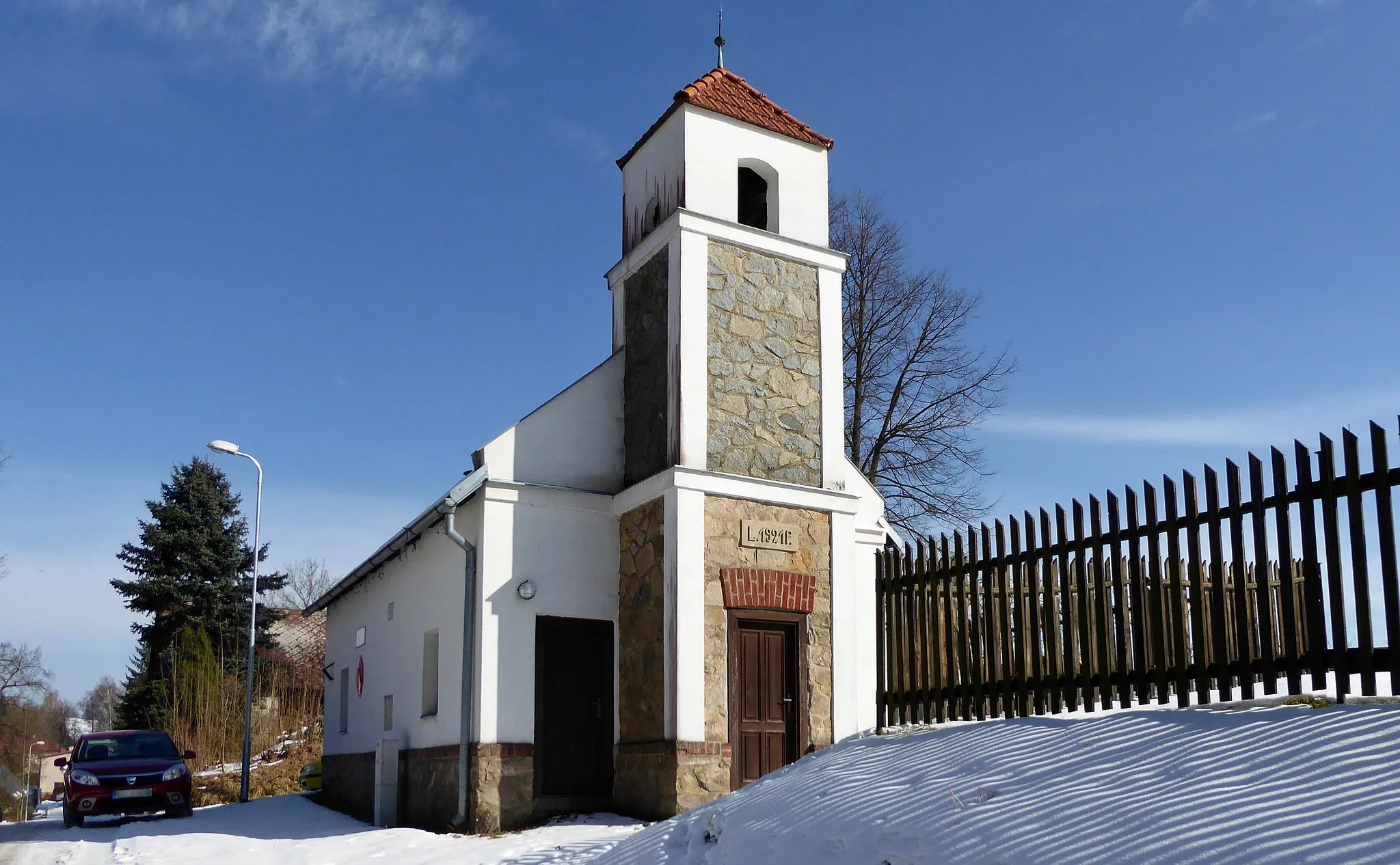 Photo showing: The fire station built in 1921 (year on the wall, see photo) in the hamlet of "Možděnice", part of village "Vysočina". The Volunteer Fire Corps was in the settlement of "Možděnice" founded in 1906. After the demolition of the wooden bell tower in 1922, the bell was hung in the tower of the fire station. Photo location: Czechia, Pardubice Region, municipality Vysočina, the hamlet of "Možděnice", "Stružinecká" knoll hill.