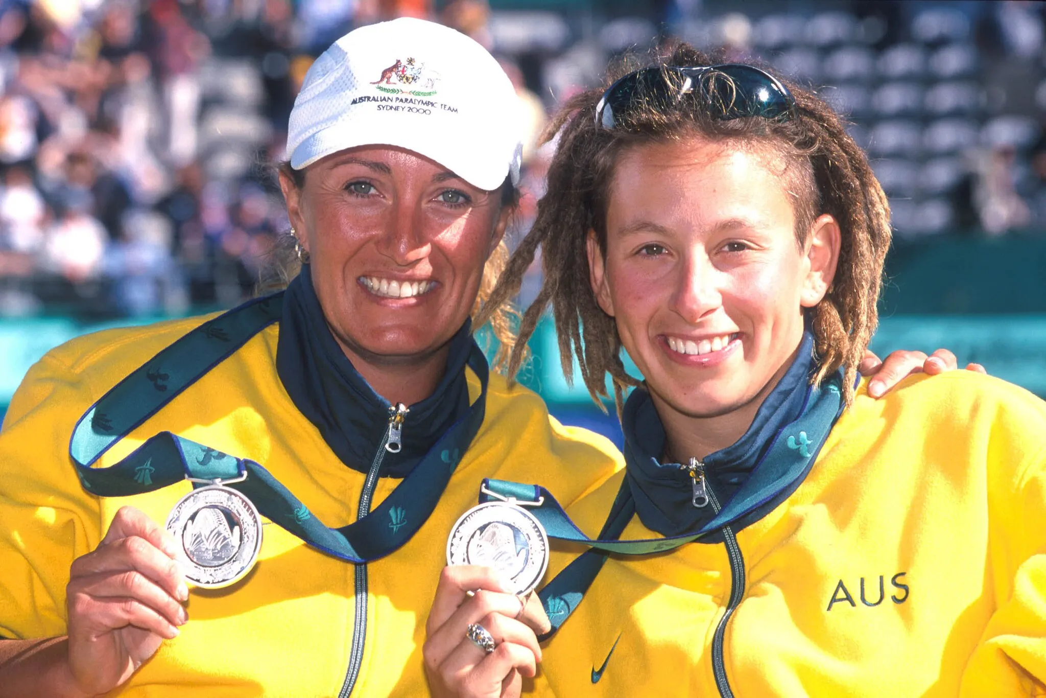 Photo showing: Australian wheelchair tennis players Daniela Di Toro and Branka Pupovac smiling as they show their gold medals, won at the Women's Doubles 2000 Sydney Paralympics