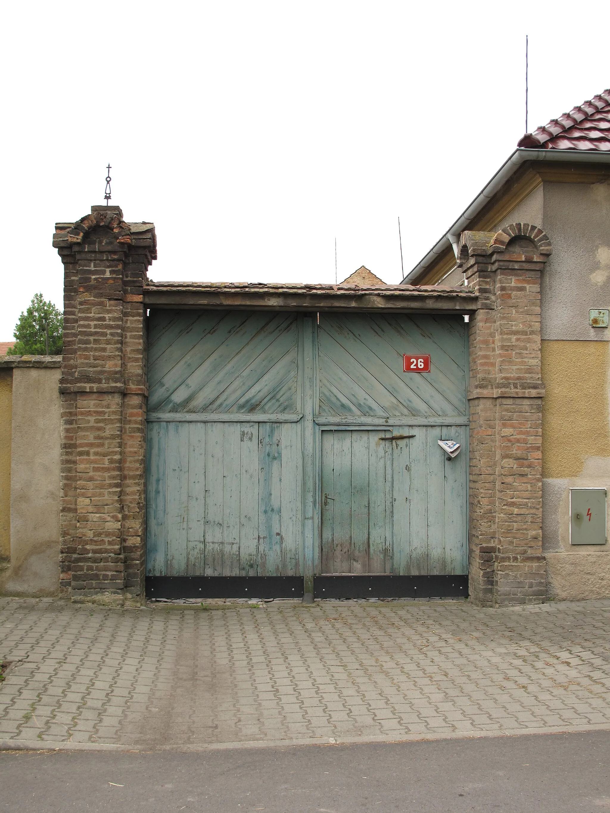 Photo showing: Green wooden gate with brick support in Úpohlavy village, Litoměřice District, Czech Republic.