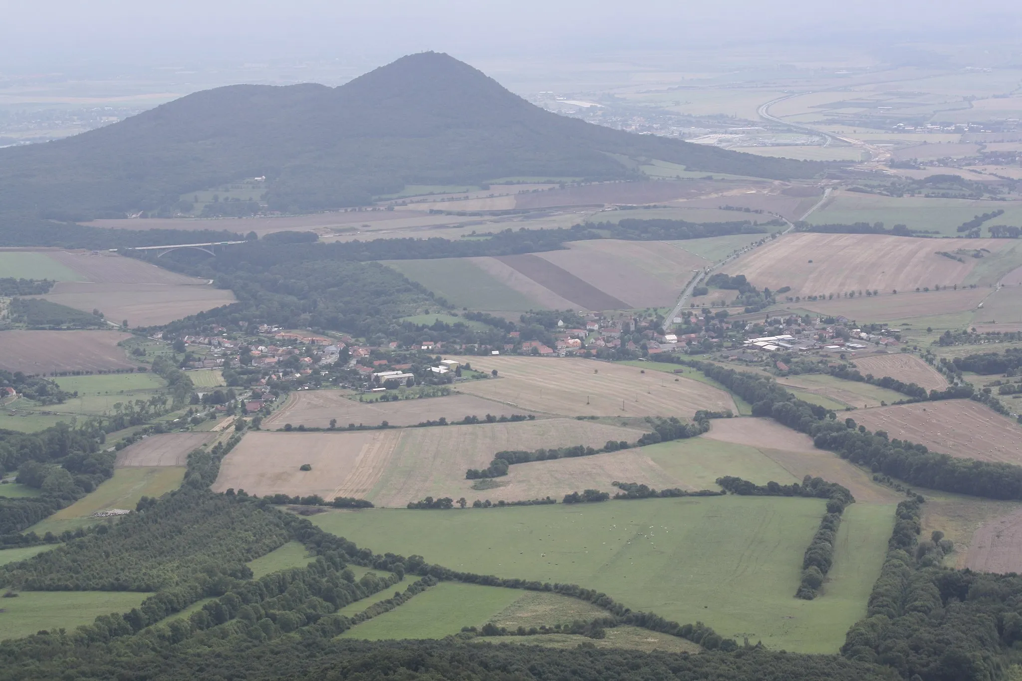 Photo showing: Lovoš hill (570 m) Velemín village and highway D8 within in the works as seen from Milešovka Hill, České středohoří, Czech Republic.