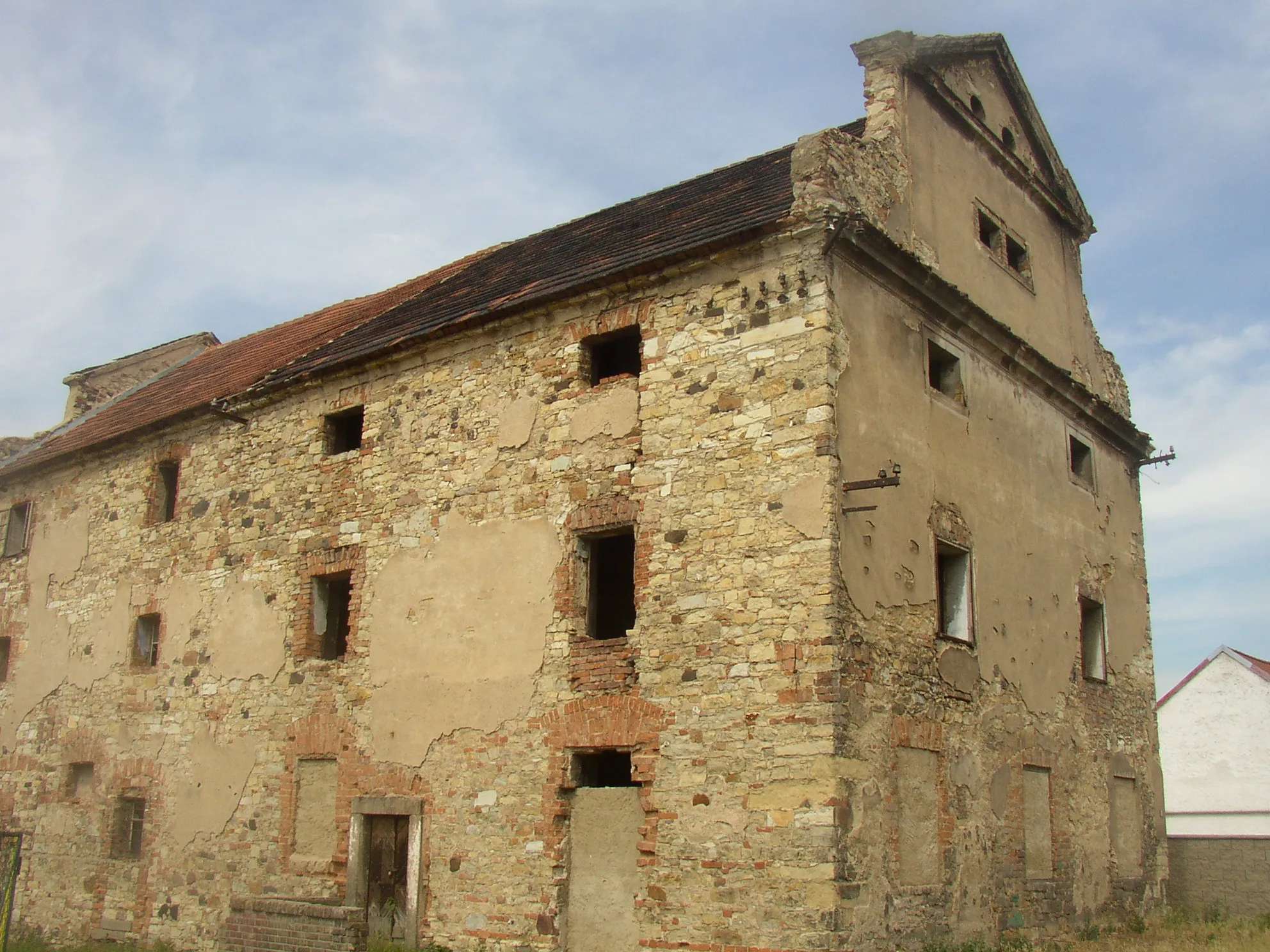 Photo showing: Mlékojedy, Litoměřice District, Czech Republic. An old granary fallen into disrepair next to NW corner of the village square.