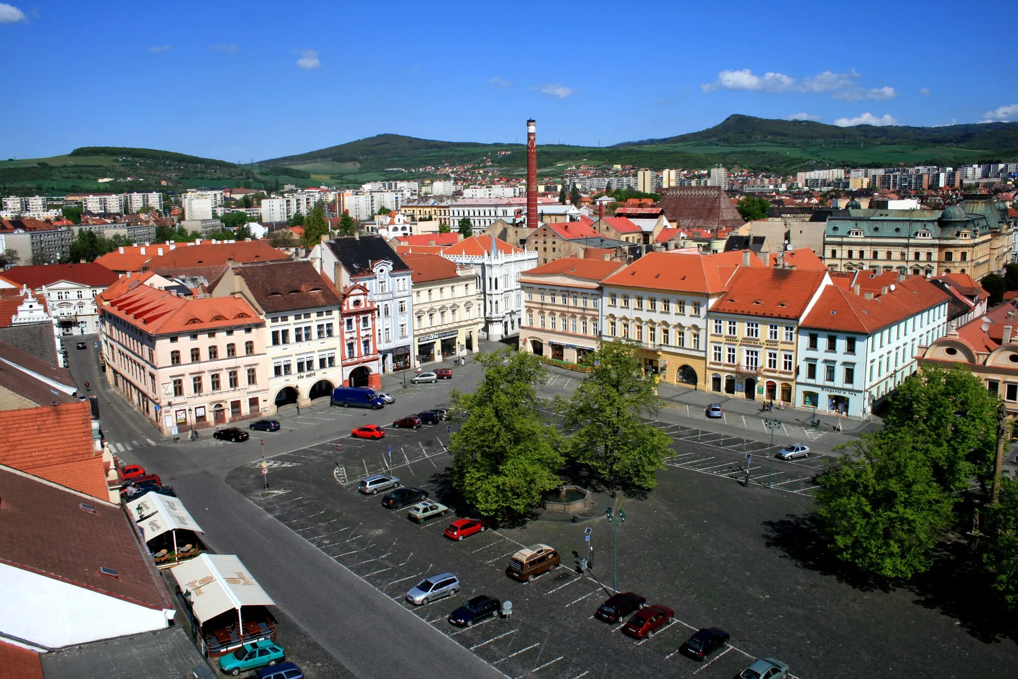 Photo showing: A view of main square of Litoměřice from House “Goblet”, Czech Republic. W half of the square with brewery (originally a medieval castle) beyond its NW corner. On a slope in the background village of Miřejovice, the horizon is framed with hills of the České středohoří: left Bídnice (361 m), middle Plešivec (509 m), right Hradiště (545 m).