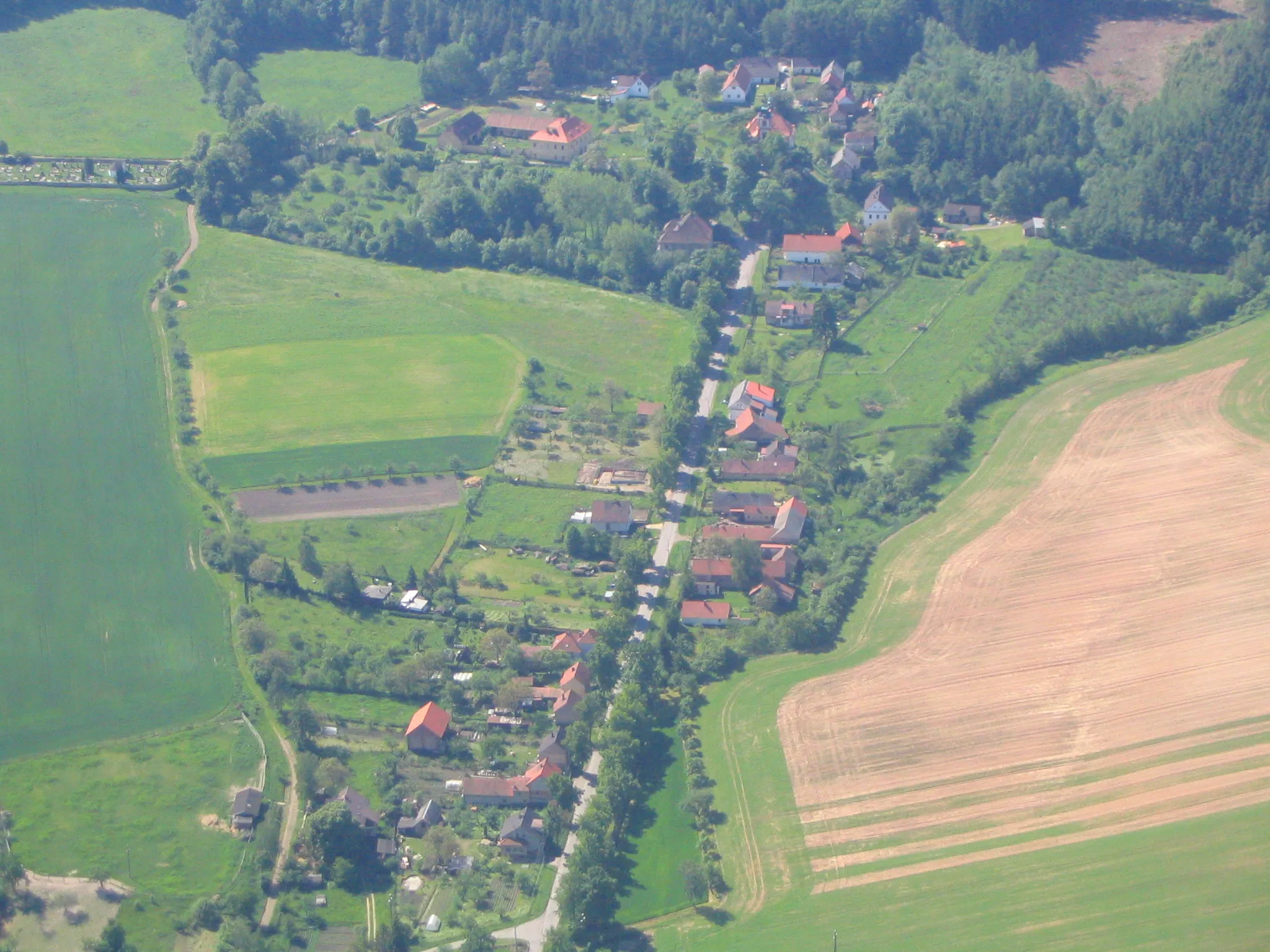 Photo showing: Letecký pohled na jižní část Petrovic u Rakovníka (uprostřed nahoře kostel, vlevo od něj fara a dále vlevo hřbitov)