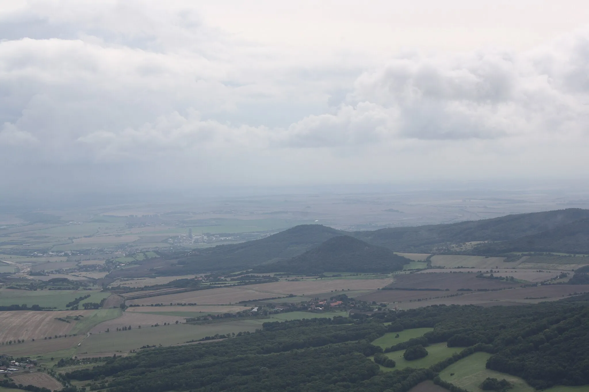 Photo showing: Březno village (Velemín municipality) with Boreč hill (446 m) and Ovčín hill (431 m) on the right as seen from Milešovka Hill, České středohoří, Czech Republic.