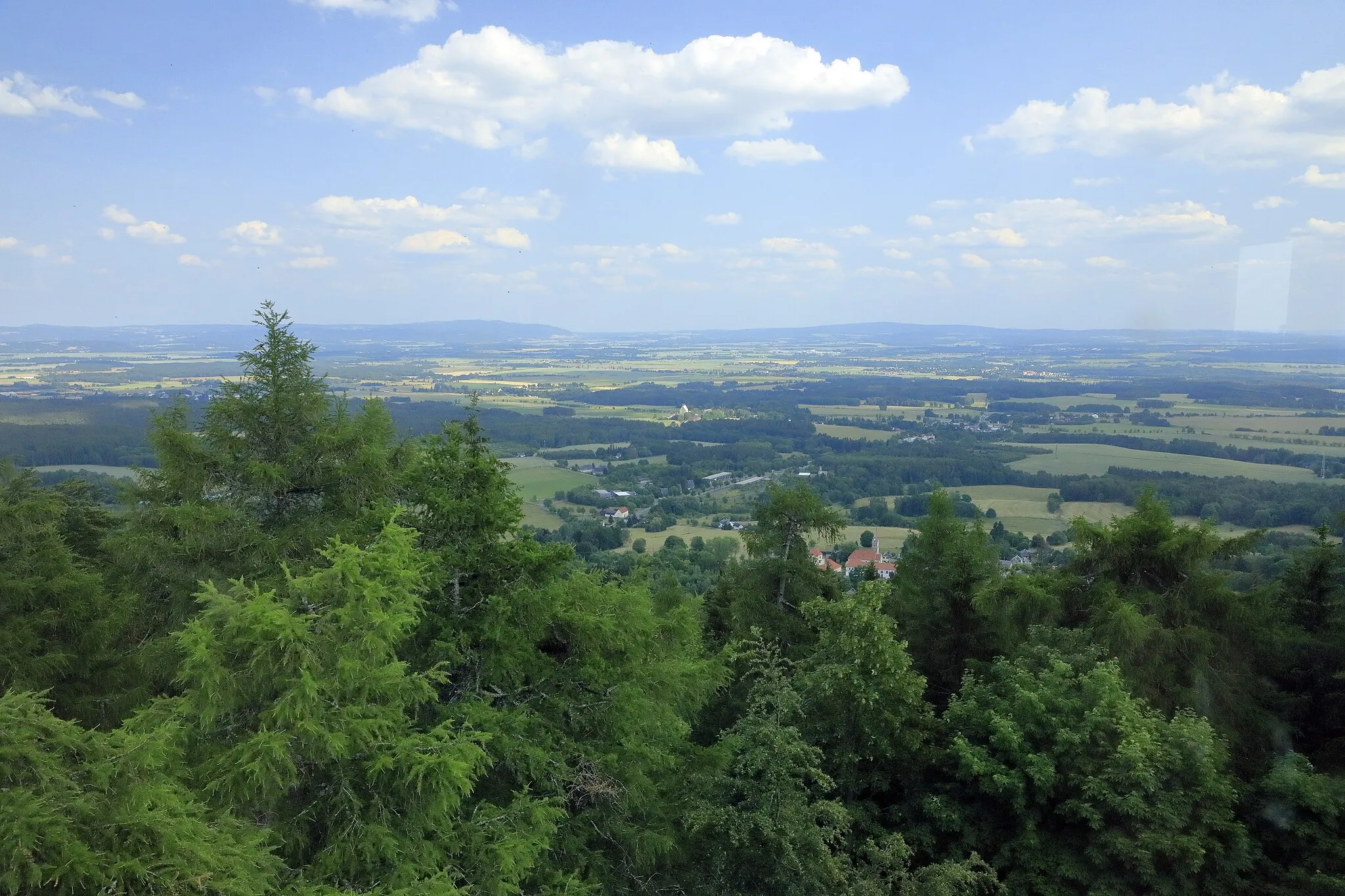 Photo showing: Vom Kapellenbergturm Richtung Südwest, von der Ortschaft Schönberg sind nur die Dachpartien des Schlosses zu sehen. Der Gebirgszug links an der Kimm ist der Kaiserwald, rechts daneben liegt der Oberpfälzer Wald.