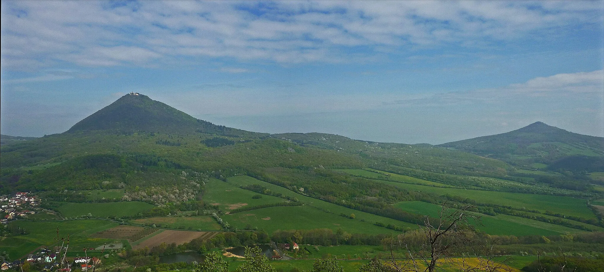 Photo showing: Blick von der Burgruine Wostrey (Hrad Ostrý) im Böhmischen Mittelgebirge zum Milleschauer (Milešovka) und Kletschen (Kletečná)