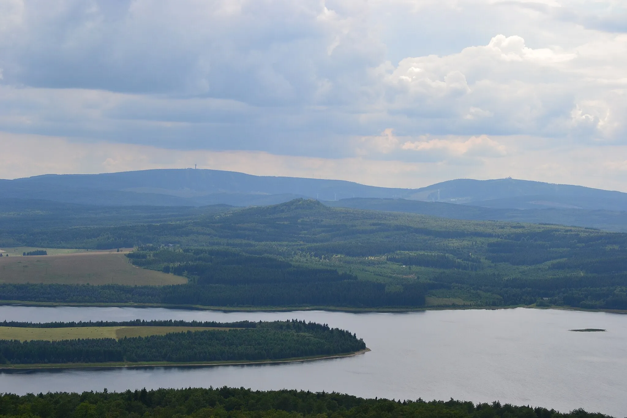 Photo showing: Blick vom Jelení hora nach Südwest. Im Hintergrund das Fichtelberg-Keilberg-Massiv, in Bildmitte der Velký Špičák und im Vordergrund ist ein Teil des Stausees der Talsperre Preßnitz erkennbar.