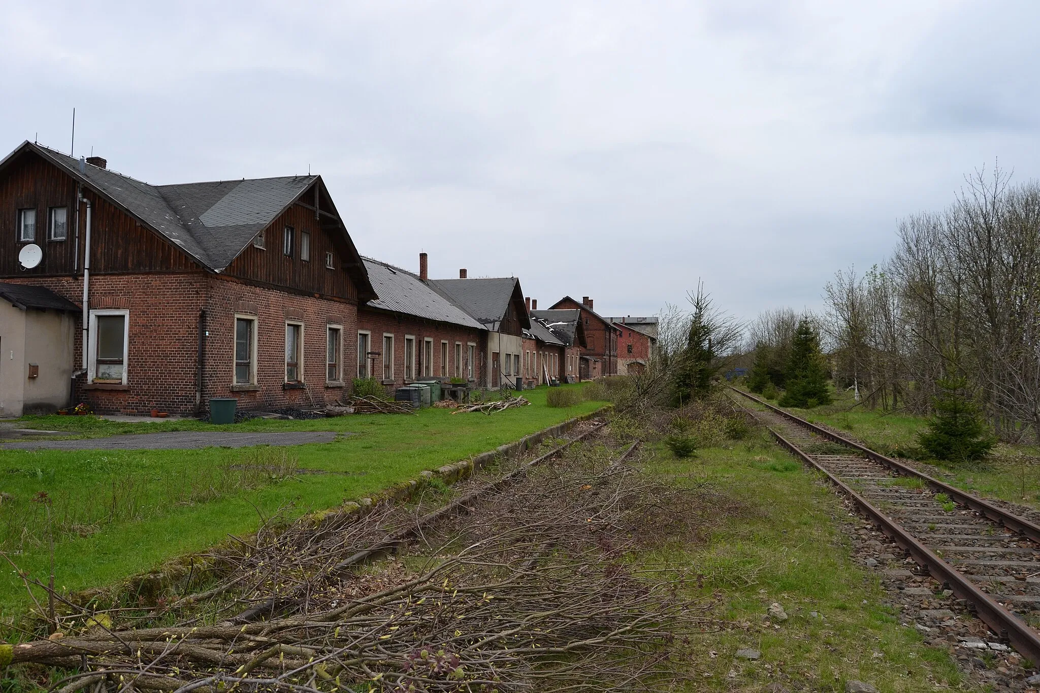 Photo showing: Blick auf einen Teil der stillgelegten Gleisanlagen sowie das ehem. Empfangsgebäude (links) des Bahnhofs Reitzenhain im Erzgebirge. Blick Richtung Flöha