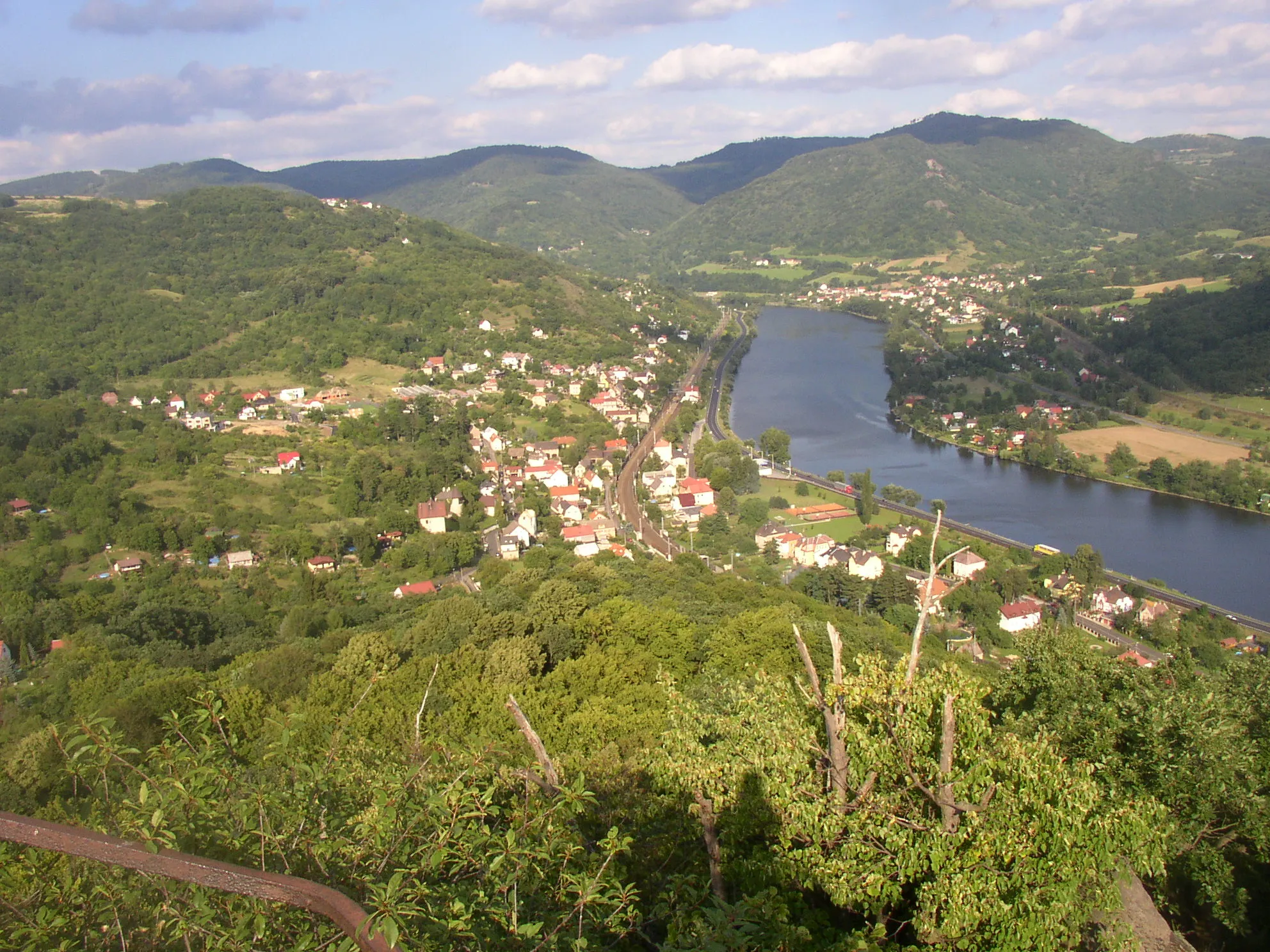 Photo showing: České středohoří, Czech Republic. A view from Mlynářův kámen (Miller's Stone) lookout point downstream along the Elbe River towards east. In foreground on the left bank vilaage of Dolní Zálezly, in background on the right bank Sebuzín, a part of Ústí nad Labem city.