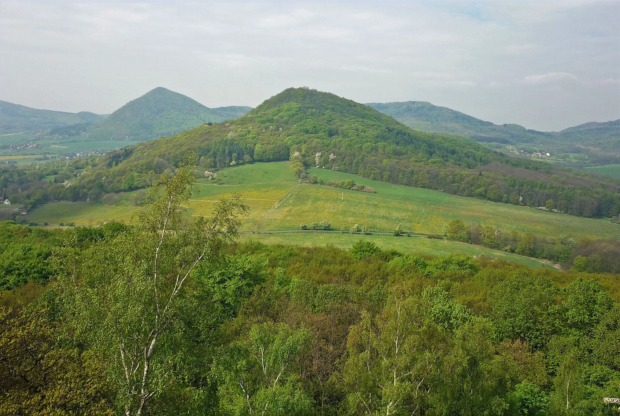 Photo showing: Blick von der Burgruine Wostrey (Hrad Ostrý) im Böhmischen Mittelgebirge zu den Bergen Lhota und Hora