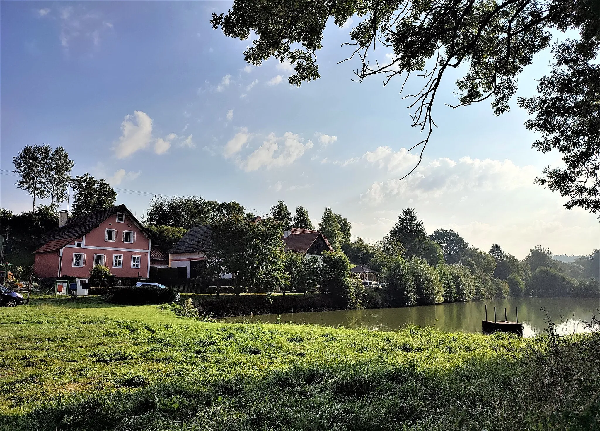 Photo showing: Mošnice, pohled z návsi na domy u rybníka