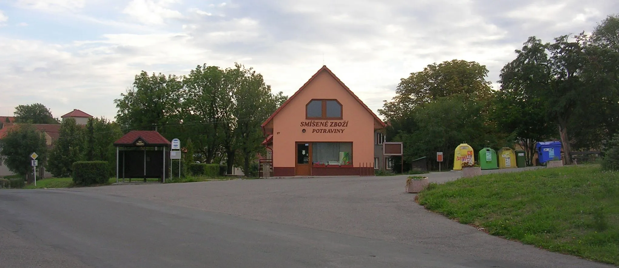 Photo showing: Chlustina, Beroun District, Central Bohemian Region, the Czech Republic. A shop and a bus stop near a pond.