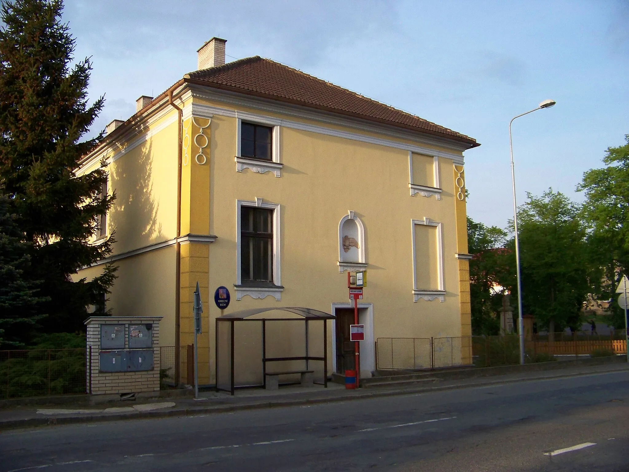 Photo showing: Říčany-Kuří, Prague-East District, Central Bohemian Region, the Czech Republic. Na Návsi, Municipal House (a former school) and a bus stop.