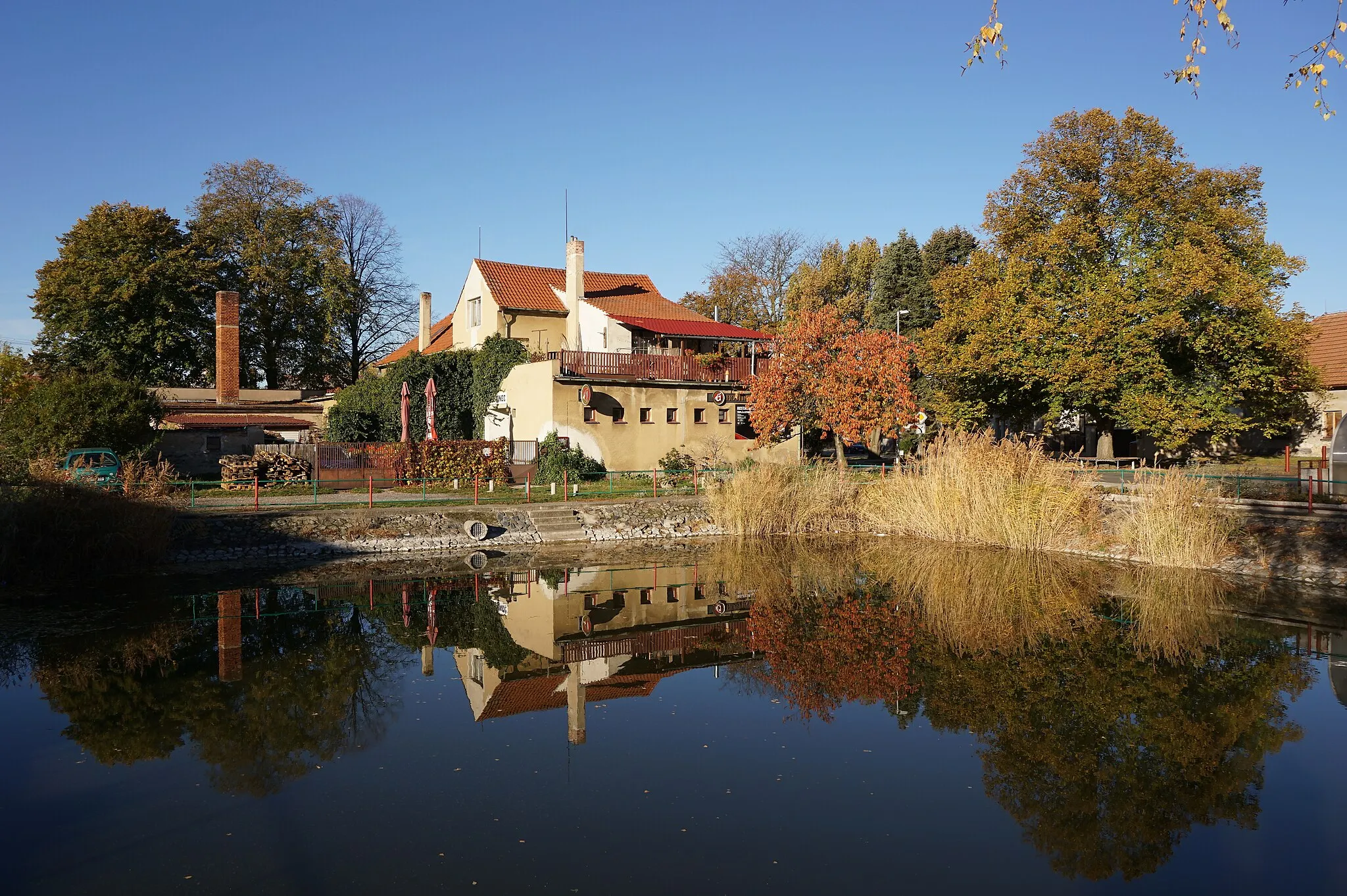 Photo showing: Dřísy - pohled přes rybníček k hostincu U Strmísků čp. 77