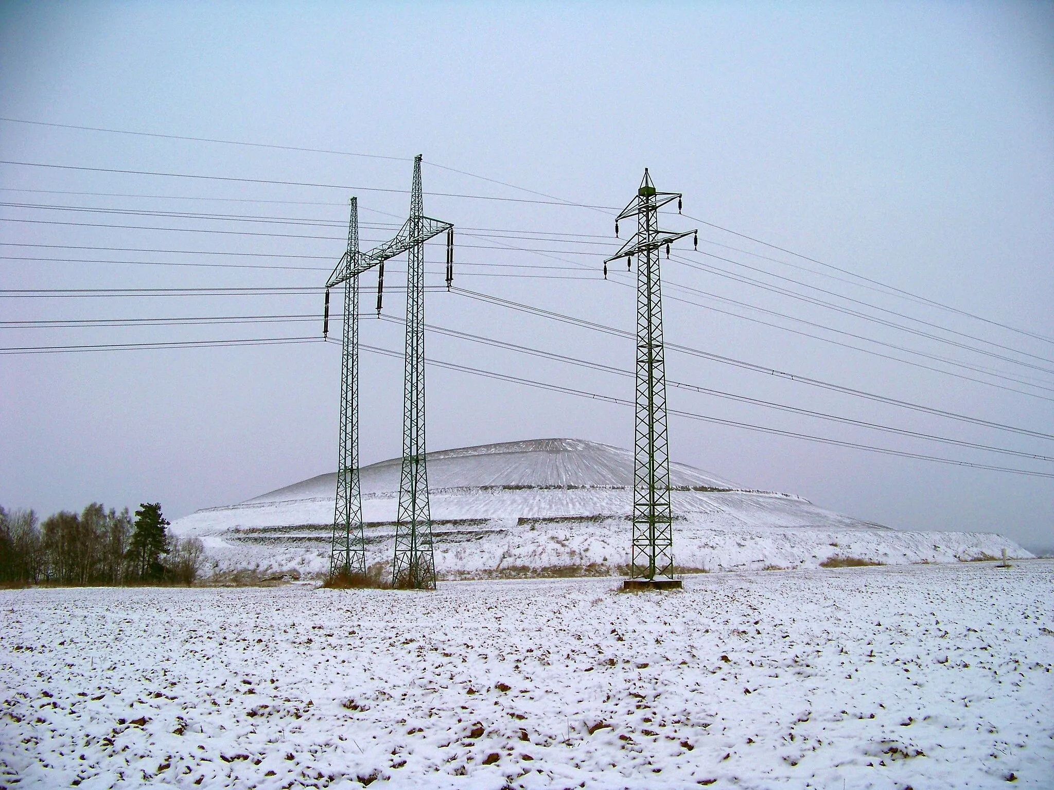 Photo showing: Tuchlovice, Kladno District, Central Bohemian Region, the Czech Republic. Slag heap. Pylon of Hradec–Řeporyje 400 kV power line (V412) on the left‎.