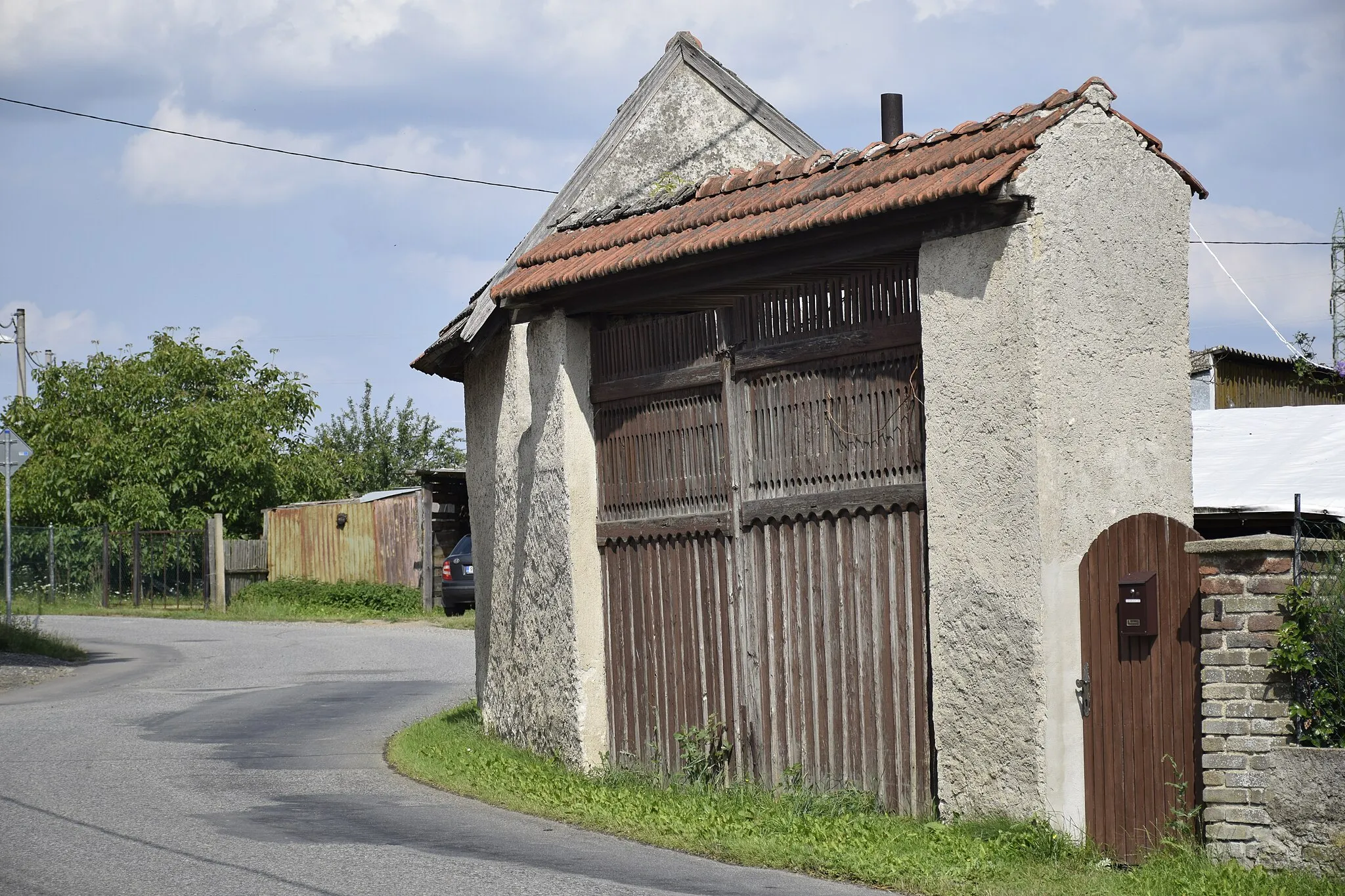 Photo showing: Wooden gate, road and gardens in Dalkovice, Benešov District, Czech Republic.