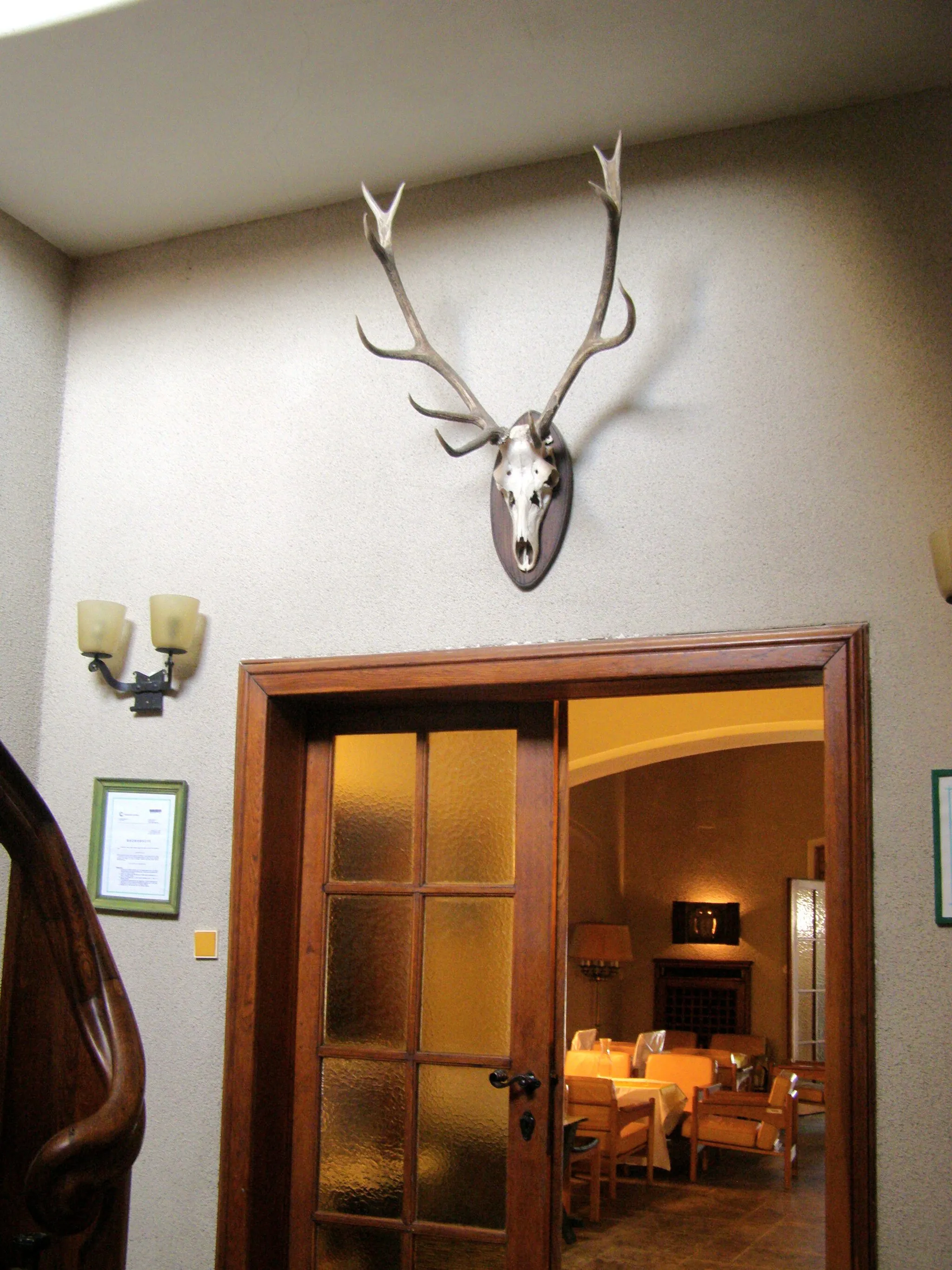 Photo showing: Area of hunting lodge Tři trubky ("Three tubes") in Brdy, Czech Republic. Ground floor of the hunting lodge, a hunting trophy above the door.