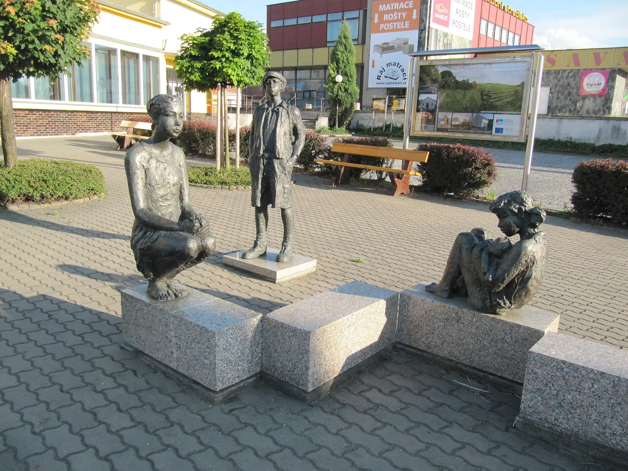 Photo showing: Kunovice in Uherské Hradiště District, Czech Republic. Sculpture Talking  (1996) and statue Schoolboy (1993) by Bořek Zeman, situated in the front of the post office.
