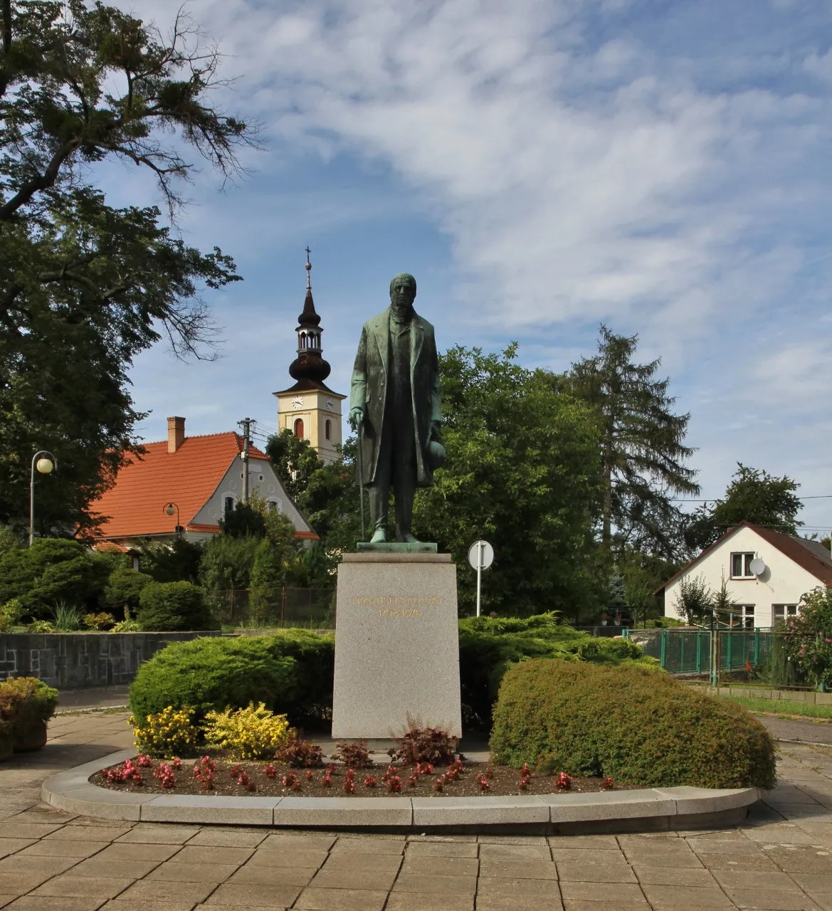 Photo showing: Statue of František Palacký in Hodslavice, Czech Republic, with the steeple of the Evangelical Church in the background