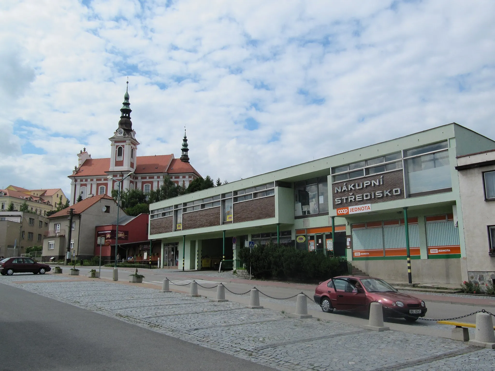 Photo showing: Polešovice in Uherské Hradiště District, Czech Republic. Center of the village with a shopping center and the church of St. Peter and Paul.