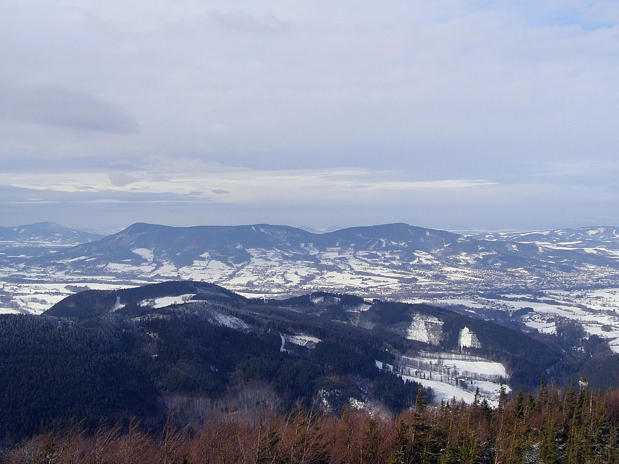 Photo showing: Moravskoslezské Beskydy, pohled z úbočí Malchoru na západ: v popředí Lysohorská rozsocha (Ostrá hora, Staškov), uprostřed Lysohorské podhůří a Ondřejník