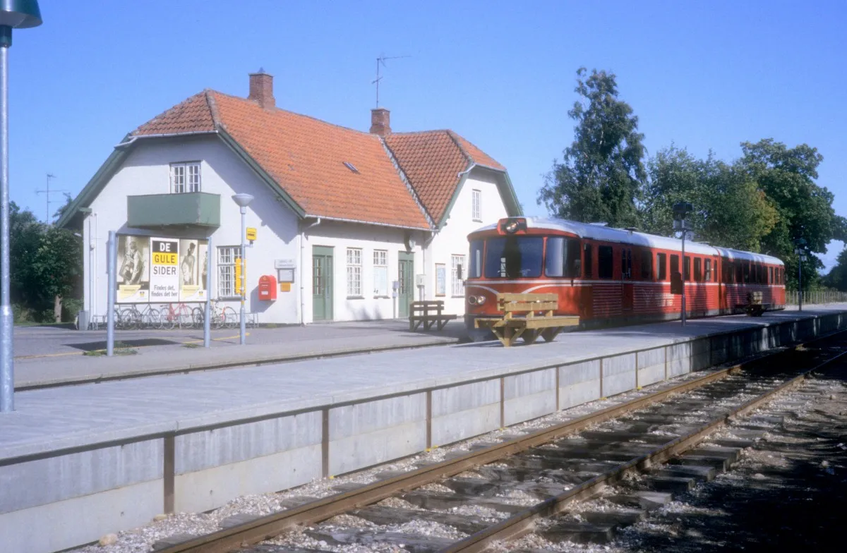 Photo showing: HHGB (Helsingør-Hornbæk-Gilleleje-Banen, auch Hornbækbanen genannt): Bahnhof Dronningmølle im September 1992. - Der Bahnhof wurde 1916 eröffnet, als die Bahn von Hornbæk nach Gilleleje verlängert wurde. - Der Triebzug am Bahnsteig fährt in Richtung Gilleleje.