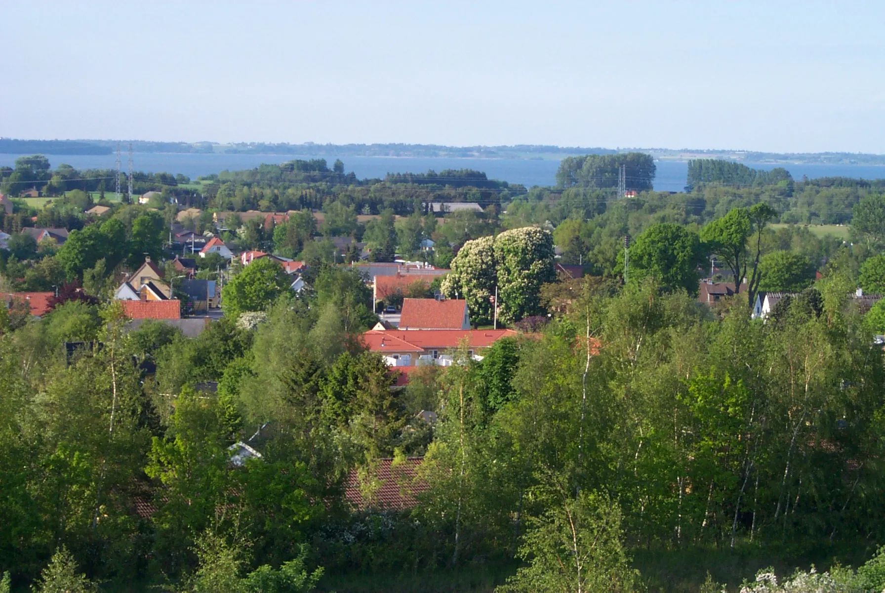 Photo showing: This pictures shows rooftops from the town Ølsted with the lake Arresø in the background. The picture is taken from a hill just south of Ølsted towards north.