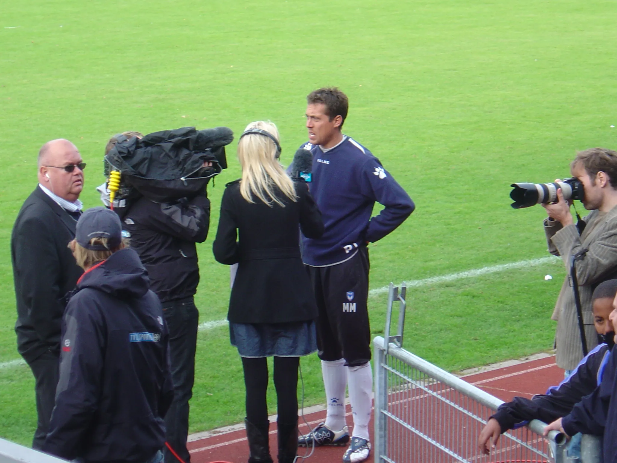 Photo showing: Football coach Michael Madsen for the Danish football club FC Amager being interviewed by TV 2 Sport reporter Tina Müller after the Danish Cup home match on 28 September 2008 against Danish Superliga club Odense Boldklub, that won the game 3-1.