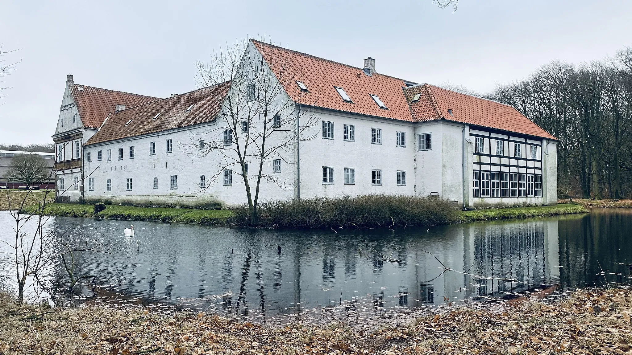 Photo showing: Brejninggaard set fra nordvest med voldgraven i forgrunden. Østfløjen længst til venstre, nordfløjen og den nyere vestfløj længst til højre.