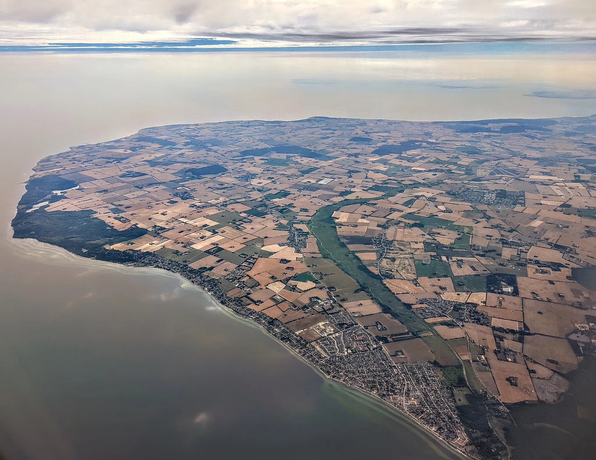 Photo showing: Aerial view of Strøby Egede (lower right) through Køge Sønakke (leftmost tip) along the near shore, looking southeast from over the bay Køge Bugt, 31 July 2022