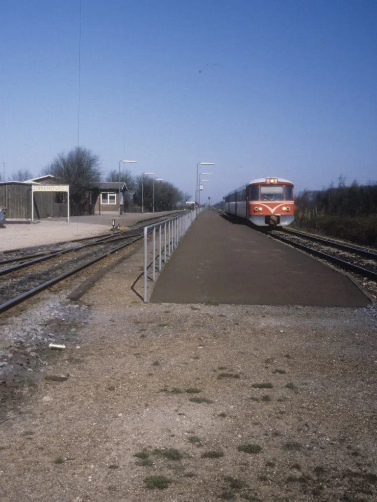 Photo showing: LJ (Lollandsbanen) Triebzug (Ym + Yp + Ys) Haltepunkt Orehoved am 14. April 1981. - Der Haltepunkt wurde 1982 geschlossen, und ab dem Jahr funktionierte der ehemalige Bahnhof und spätere Haltepunkt nur als ferngelenkte Kreuzungsstation. - Aber seit dem Frühling d.J. gibt es eine vorläufige Station, die an den Tagen, an denen die Bahnbehörde BaneDanmark an den Vorbereitungen zur künftigen Fehmarn Belt-Verbindung (u.a. mit der Errichtung neuer Brücken) arbeitet und deshalb den Bahnverkehr zwischen Orehoved und Nykøbing F unterbrechen muss, Endstation der DSB-Züge zwischen Kopenhagen und Nykøbing F ist. - Die vorläufige Station wird bis 2021 in gewissen Perioden im Betrieb sein. - An diesen Tagen wird es dann einen SEV zwischen Orehoved und Nykøbing F mit Bussen geben.