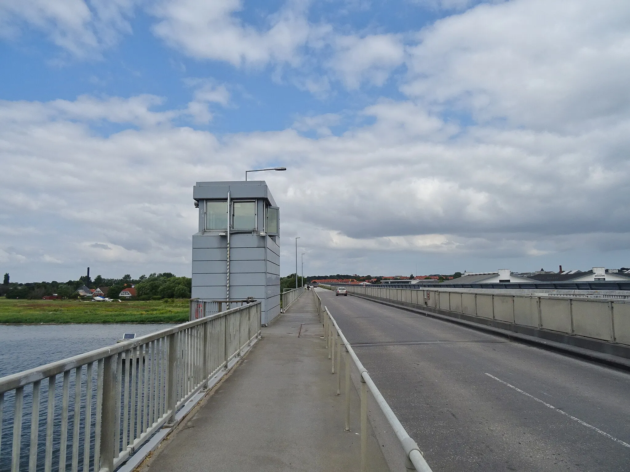 Photo showing: The Masnedsund Bridge between Masnedø and Sjælland in Denmark. The combined sidewalk and cycle lane is a part of the national cycling route 7 while the road is a part of the secondary route 153. The bridge tender house doesn't serve purpose anymore because the bridge was permanently locked in 2016.