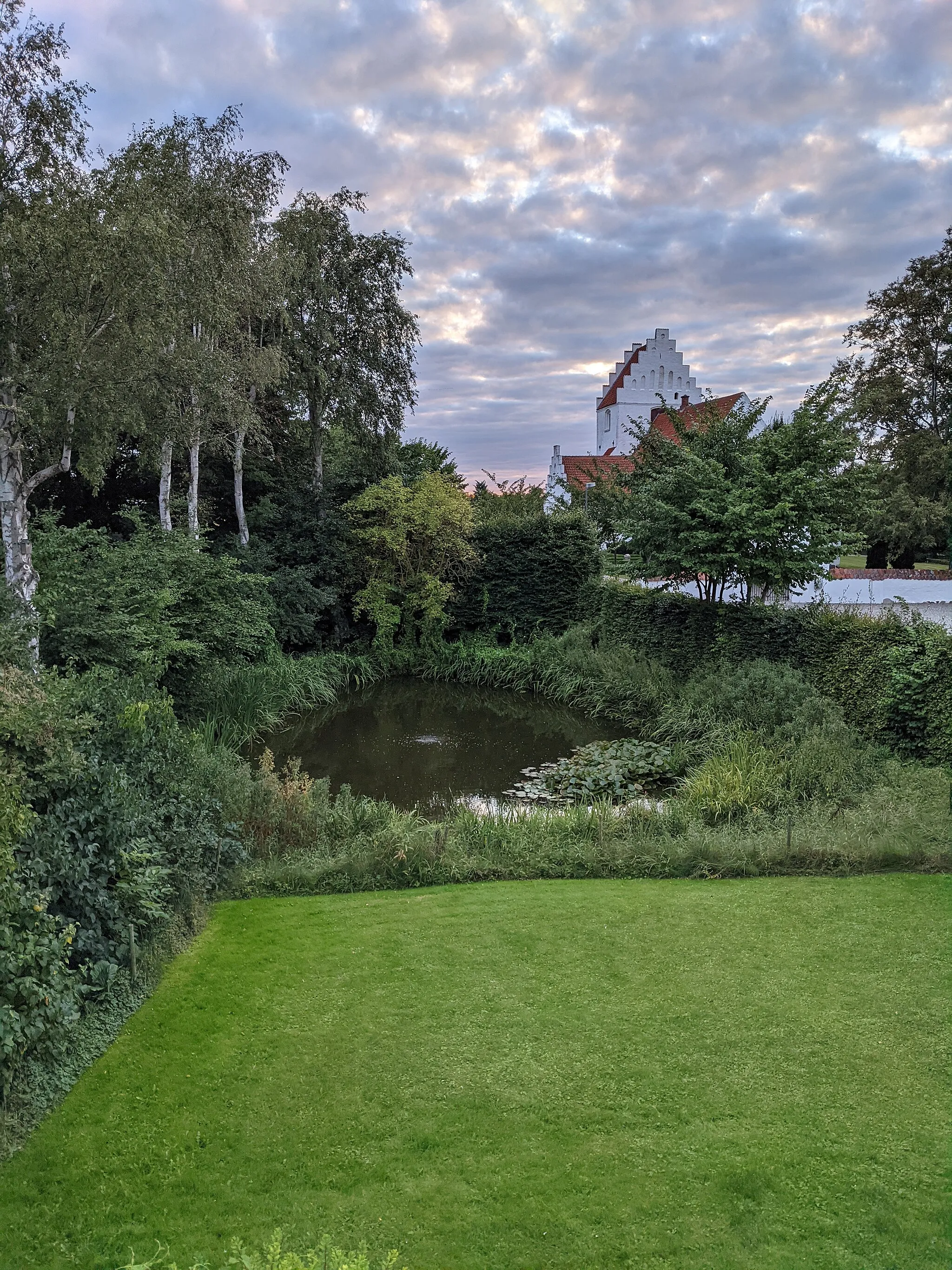 Photo showing: Church in Hunseby, with a small lake in front.