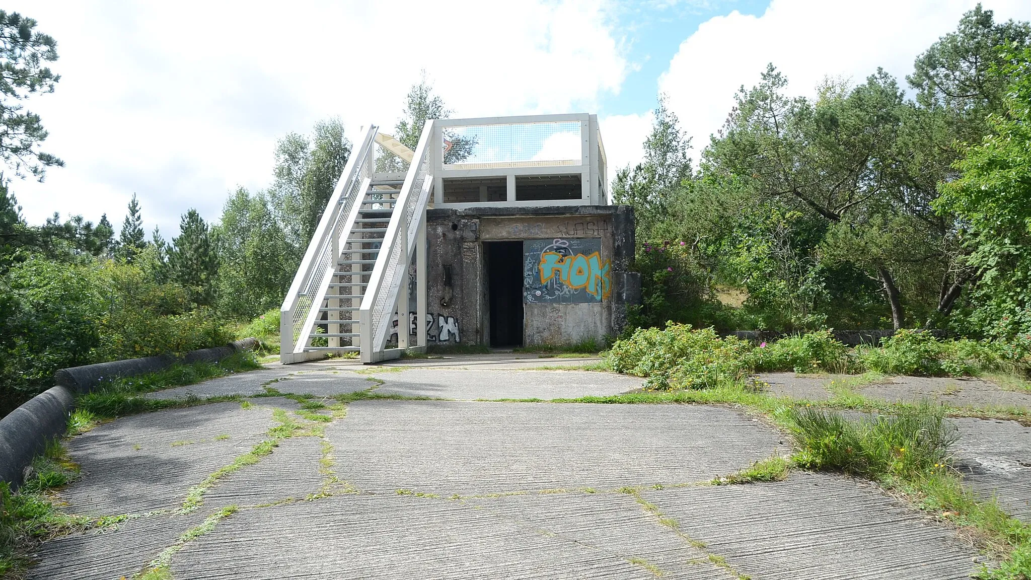 Photo showing: Nederste del af flygtningelejrens gamle brandtårn. På platformen findes infotavler. Træerne omkring bygningen er for høje til at man kan se over dem fra platformen.