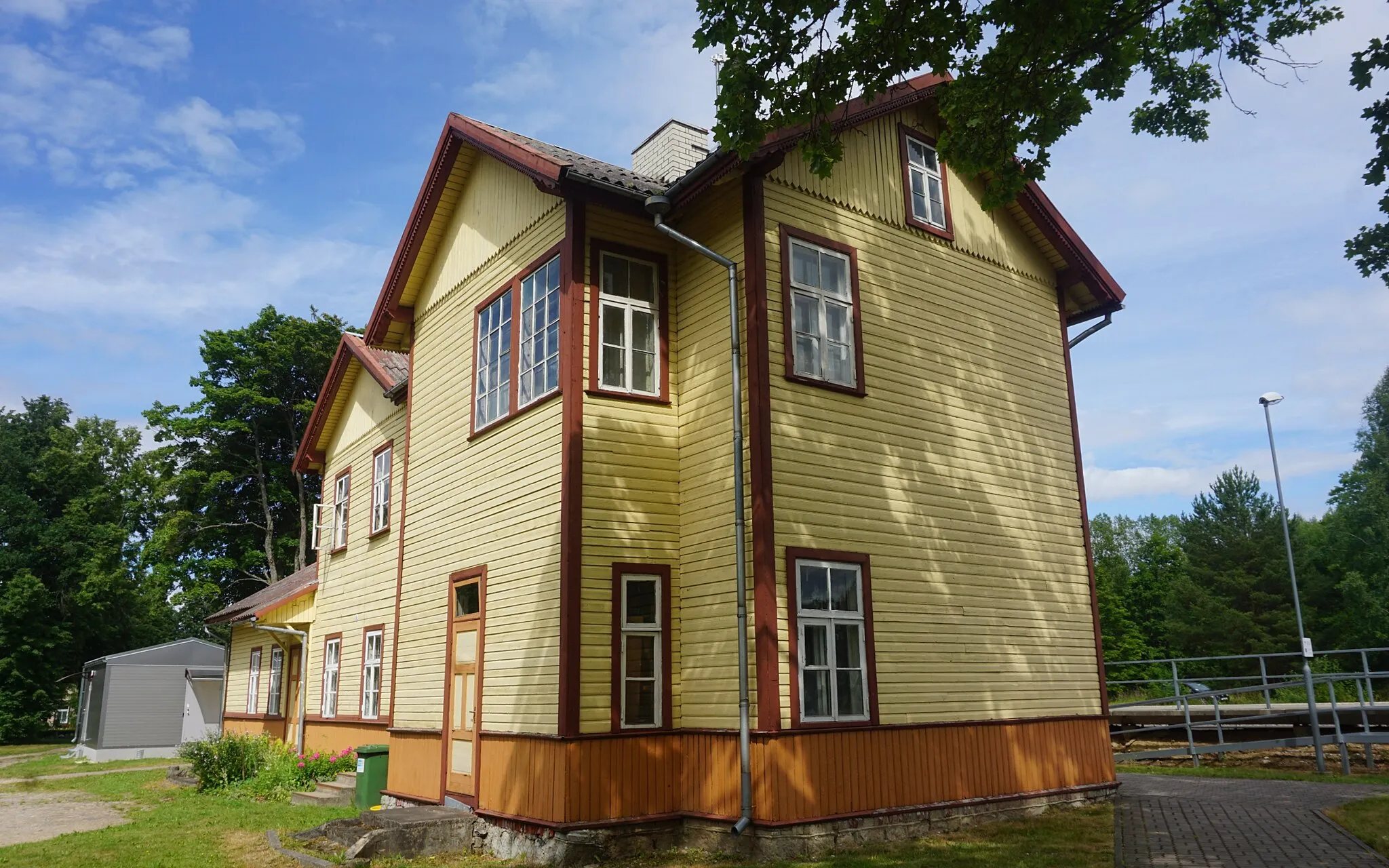 Photo showing: Võhma jaamahoone (Spordi tn 2) tagantvaates. Võhma jaamahoone valmis 1901. aastal. Kitsarööpmelise raudtee jaamahoone ehitati tüüpprojekti järgi analoogselt Lelle, Olustvere, Surju jmt jaamahoonetega.
Puidust jaamahooneid iseloomustab ühe-kahekorruseline asümmeetriline fassaad, mille ülesehitus sarnaneb laiarööpmelise raudtee jaamahoonetega. Kitsarööpmelise raudtee jaamahoonena torkab esile aga tagasihoidlikum dekoorikasutus. Hoone keskel asub läbi maja ulatuv vestibüül, millest paremal asuvas ühekorruselises külgtiivas asus reisijate ootesaal. Võhma jaamahoonele tehti 1926. aastal juurdeehitus.

2012. aastal jaamahoone renoveeriti ja praegu on ehitis Edelaraudtee Infrastruktuuri AS kasutada.